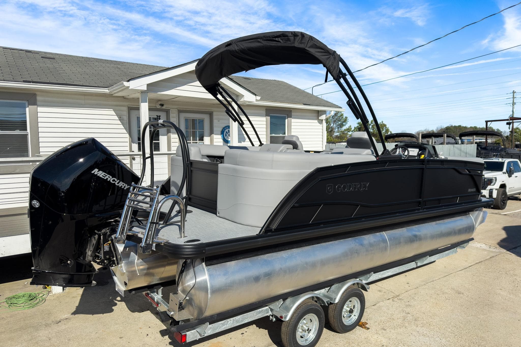 2026 Godfrey Monaco 235 Split Bench pontoon boat on trailer, featuring Mercury engine.