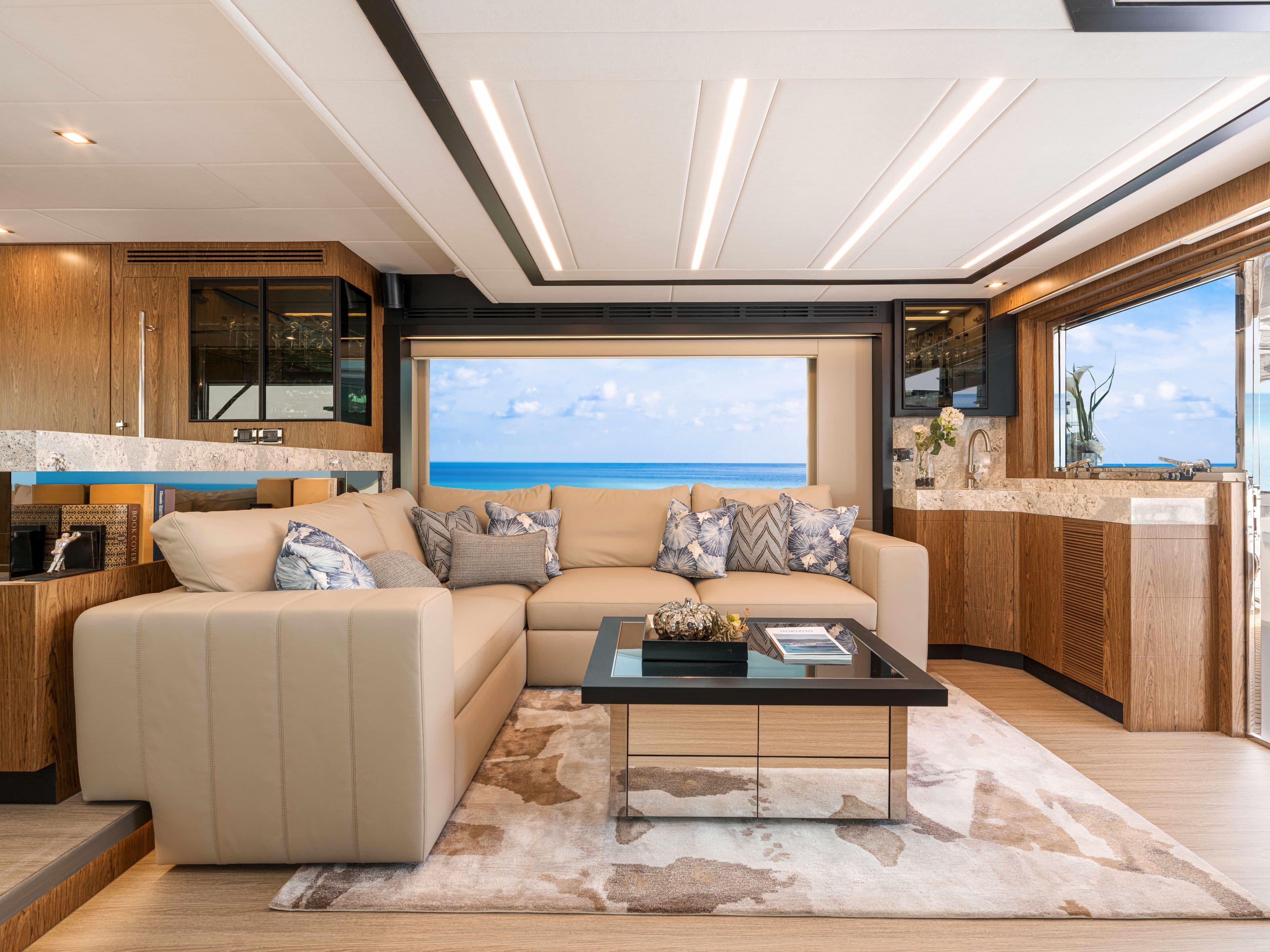 Luxurious Horizon V68 yacht interior with ocean view, featuring elegant beige sofa and modern decor.