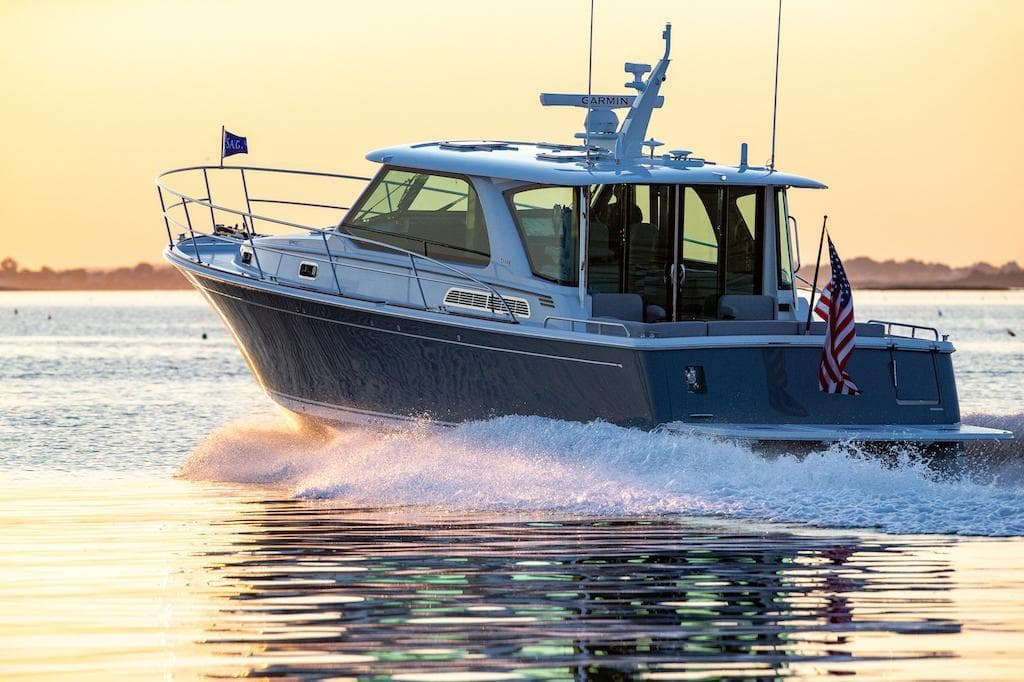 2026 Sabre 43 Salon Express cruising on water at sunset.