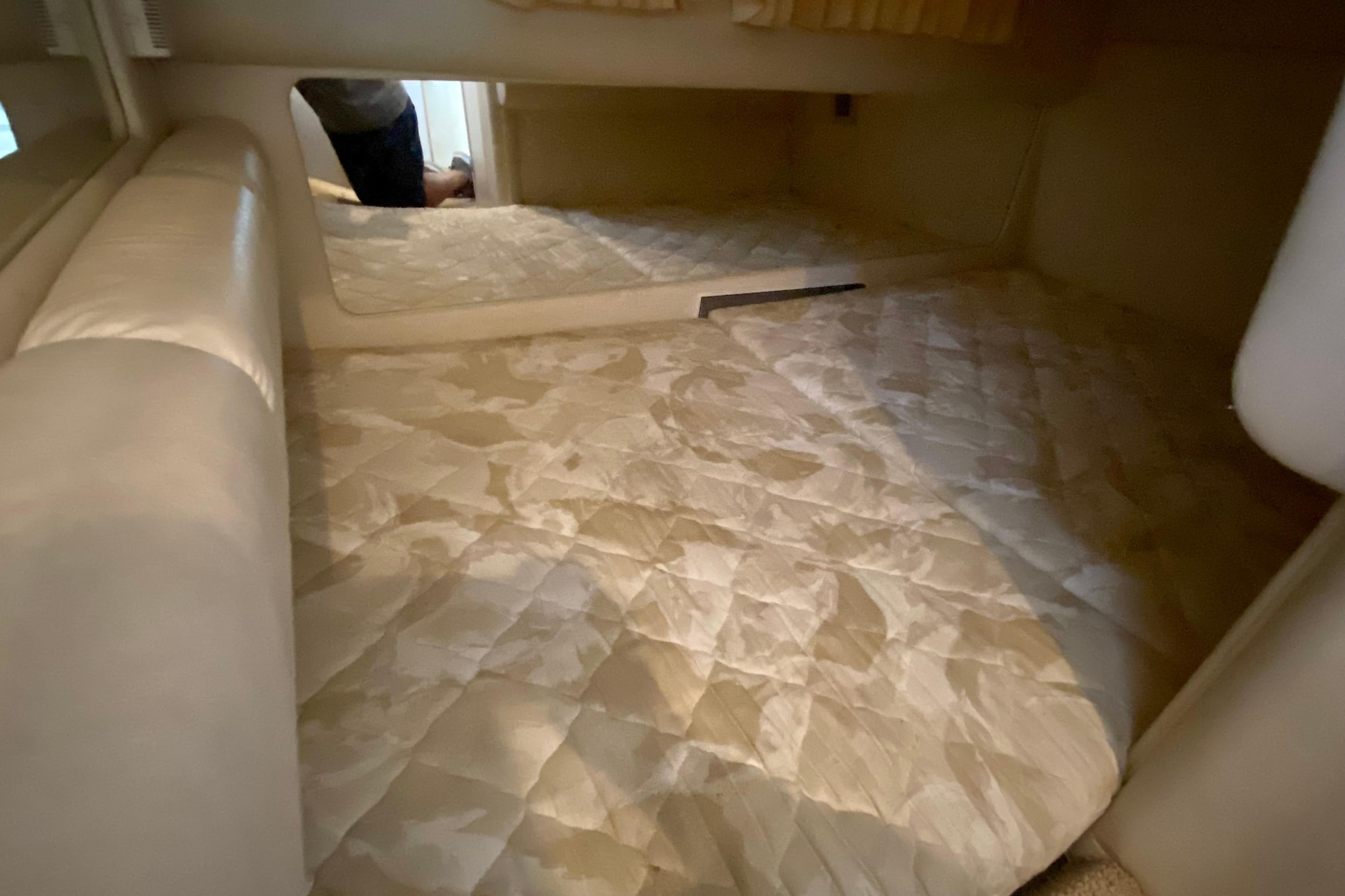 1998 Sea Ray Sundancer 310 cabin interior with beige quilted bedding.