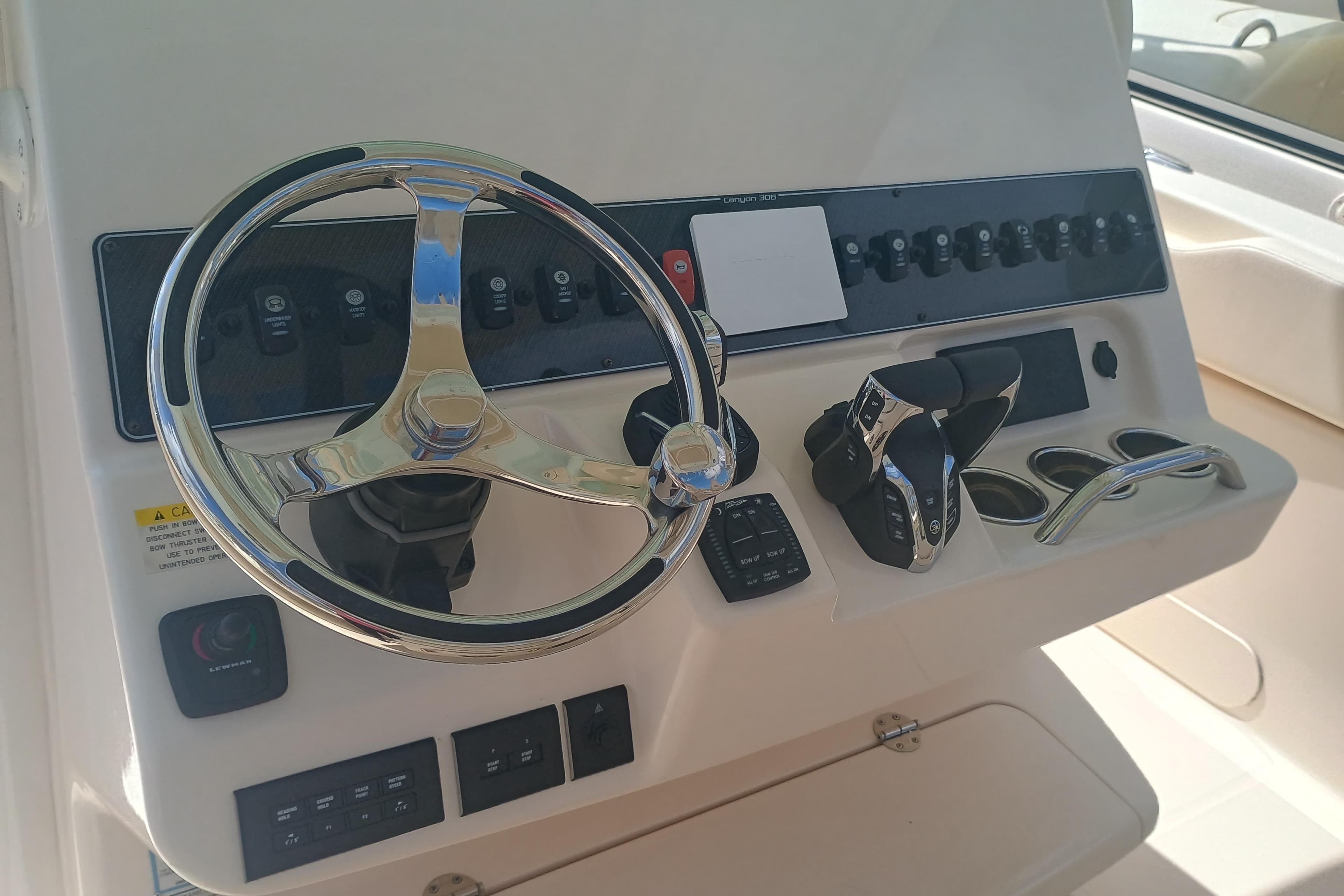 Control panel of 2025 Grady-White Canyon 306 boat with steering wheel and switches.