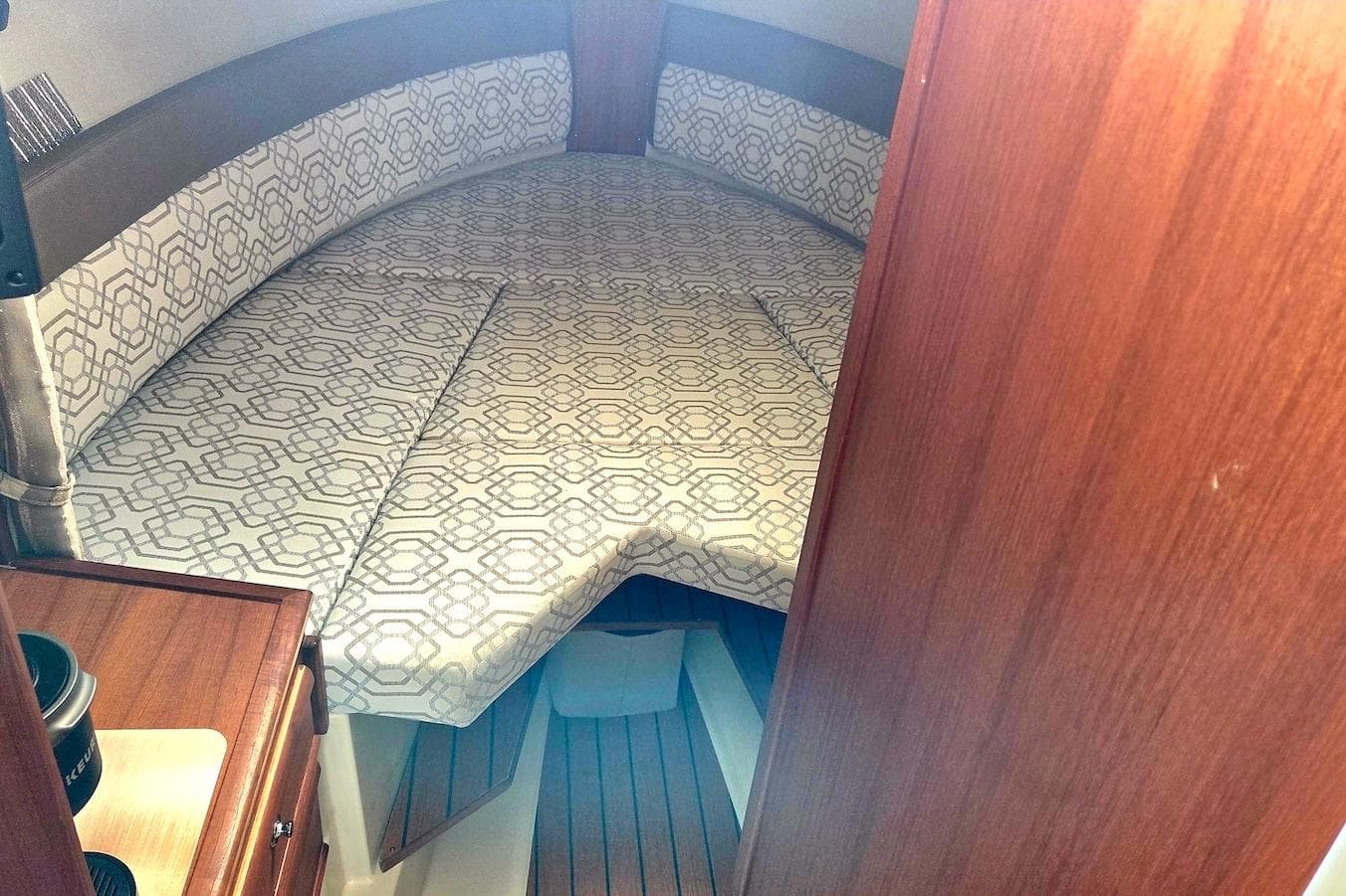 2022 Ranger Tugs R-27 cabin interior with patterned bedding and wooden accents.