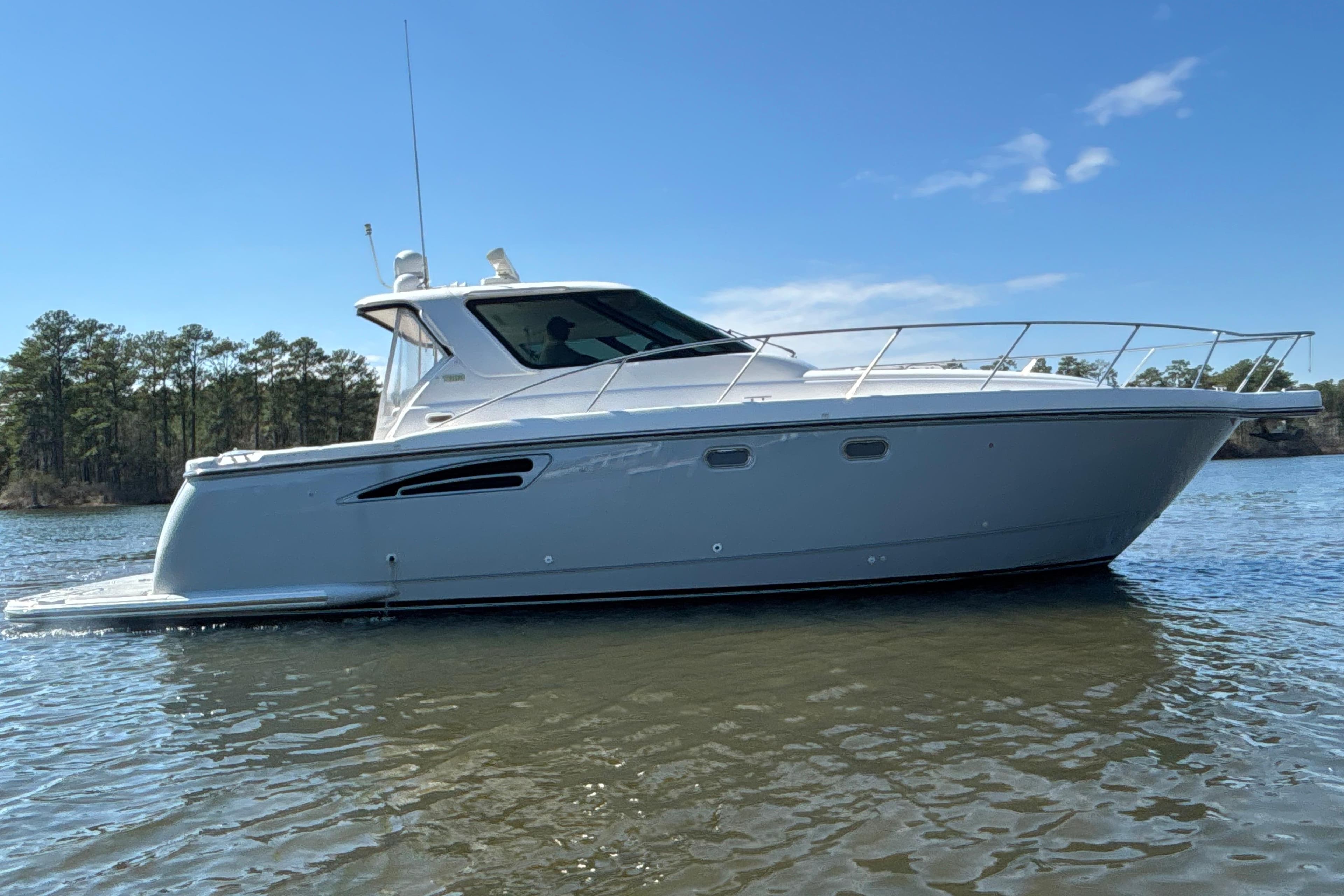 2004 Tiara Yachts 3600 Sovran cruising on a calm lake under a clear blue sky.