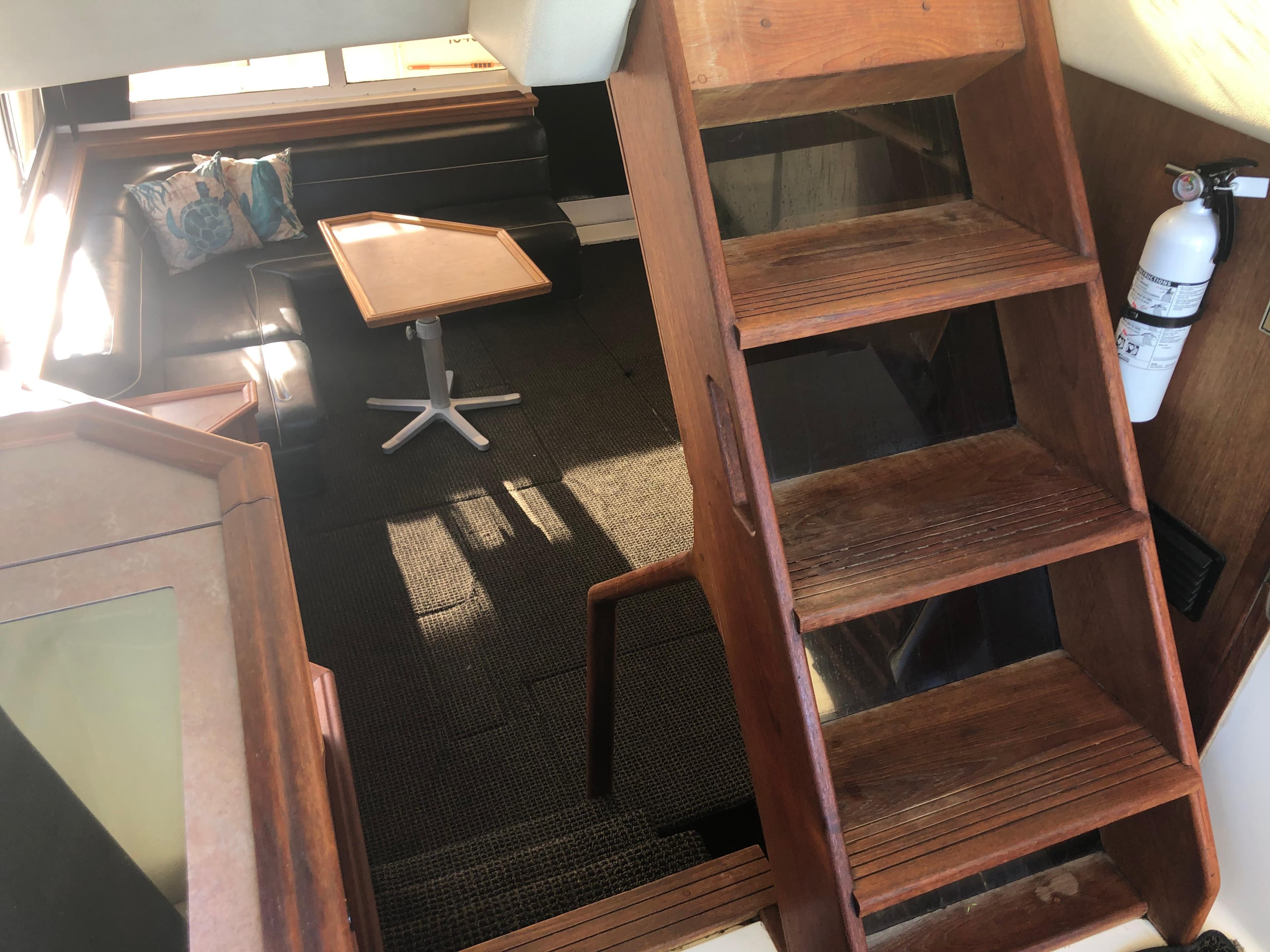 Interior of 1996 Bayliner 4788 Pilot House Motoryacht with wooden stairs and seating area.