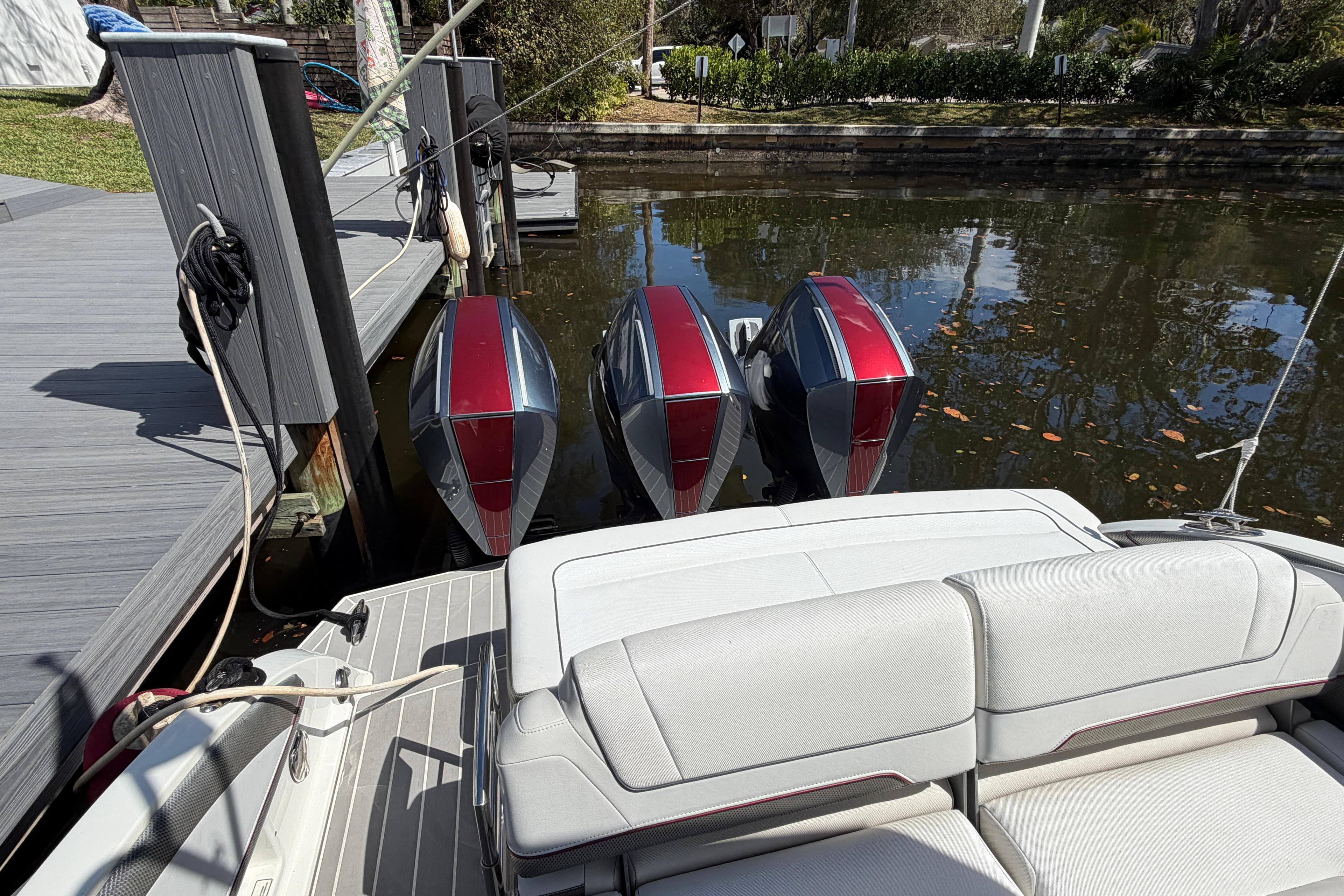 2020 Formula 330 Crossover Bowrider OB with triple outboard engines docked by the water.