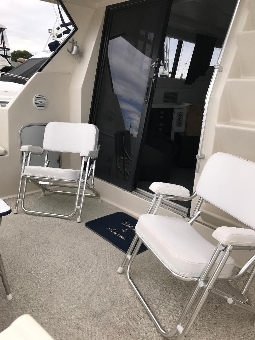 1990 Mainship Mediterranean yacht interior with white chairs and carpeted deck.