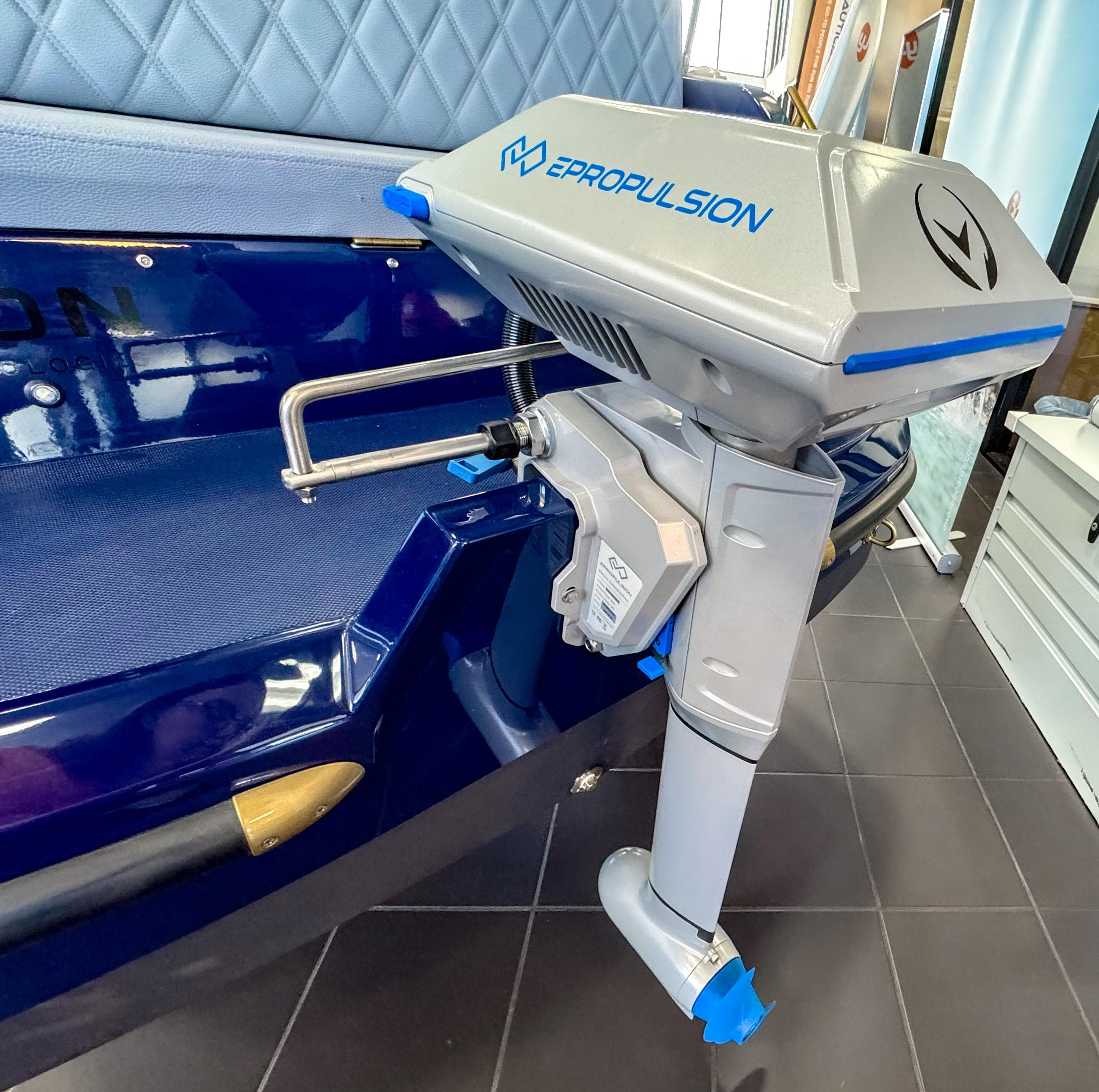 Electric outboard motor on Vision Marine Technologies Volt 180, 2025 model, in a showroom setting.