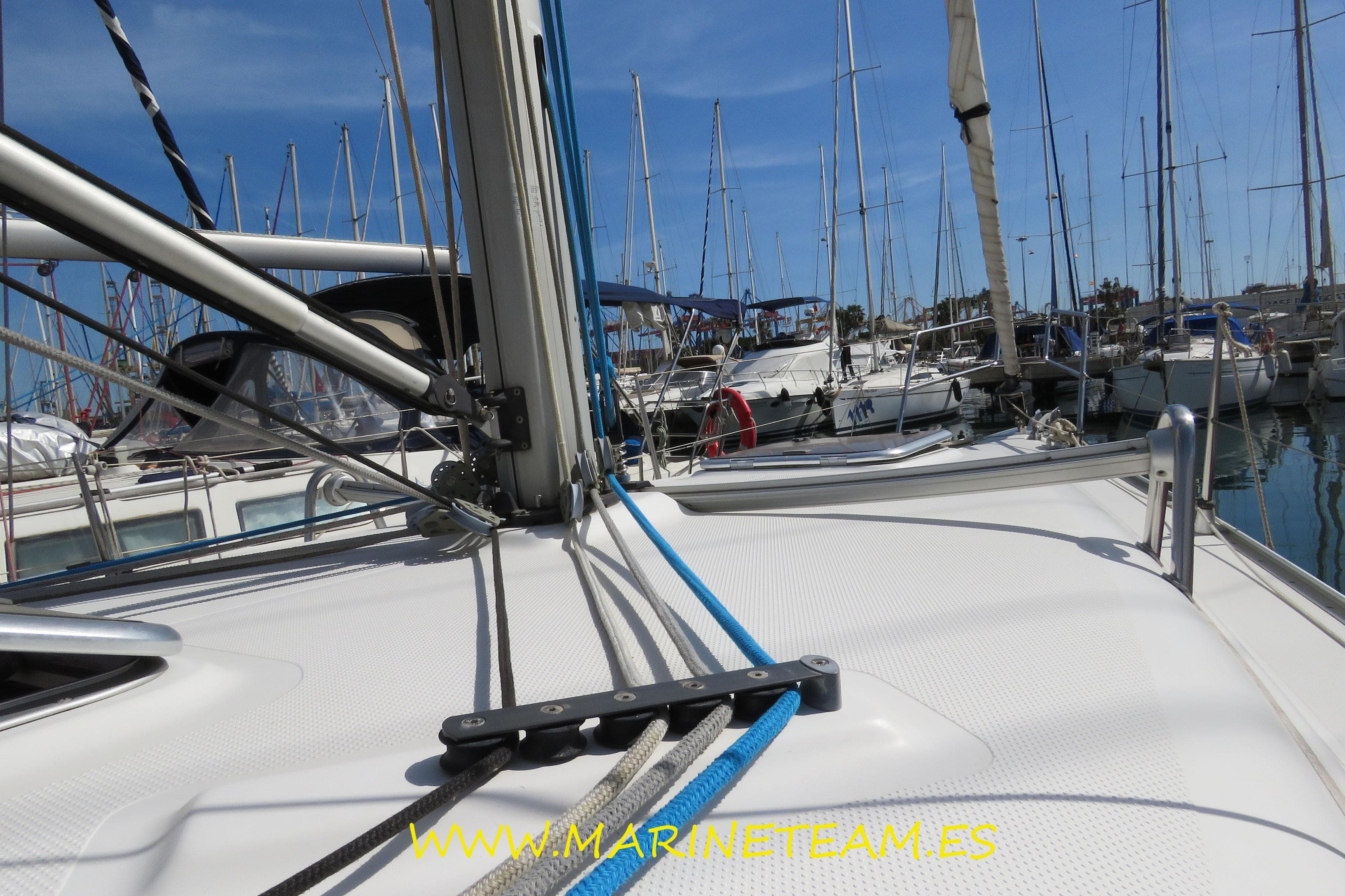 2007 Hanse 342 sailboat deck view in marina with rigging and moored boats.