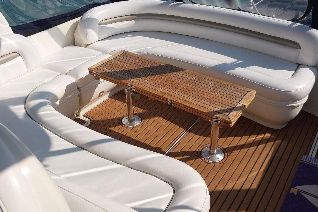 Luxurious seating area on 2004 Sea Ray 420 Sundancer yacht with wooden table.