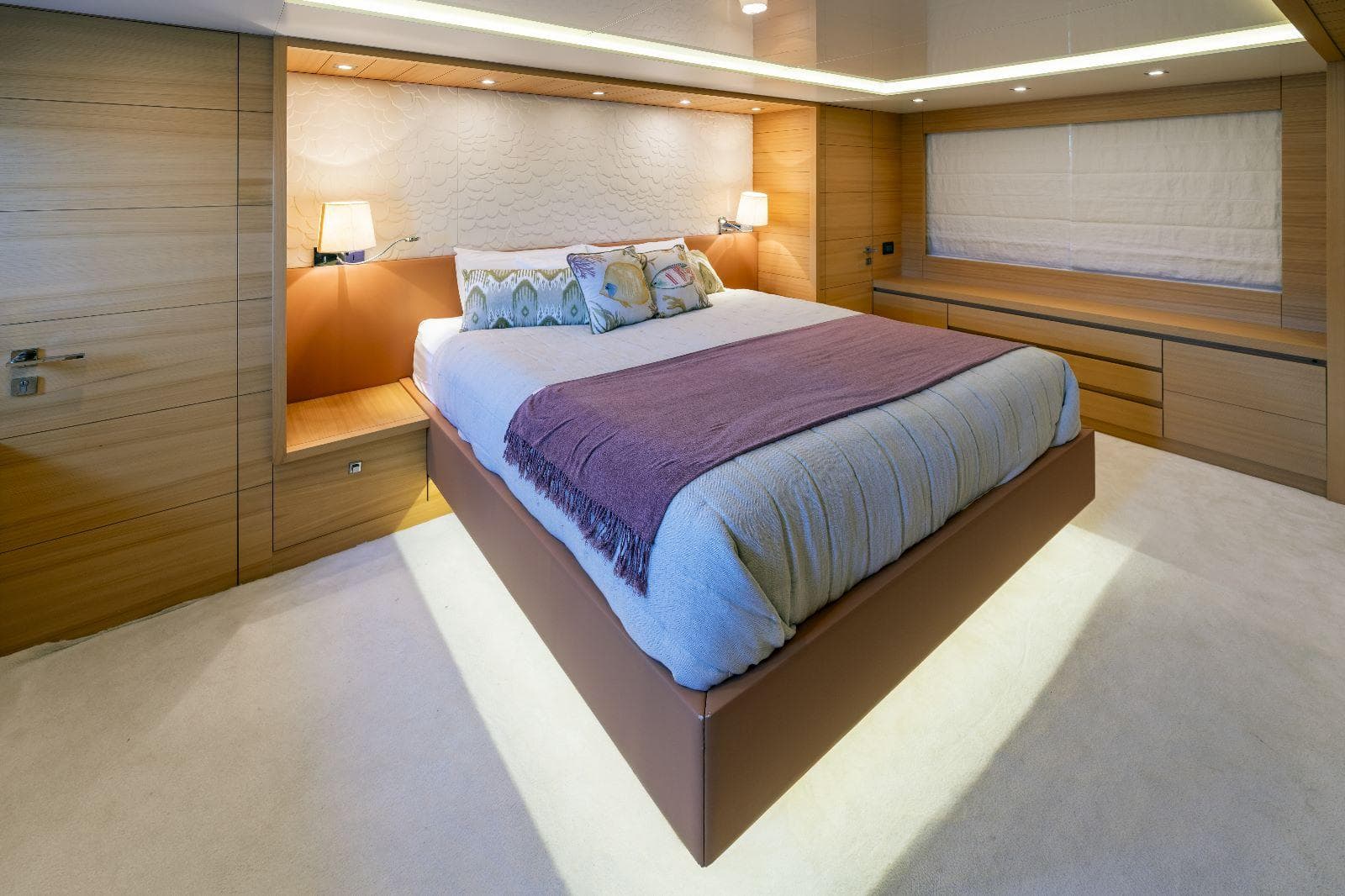 Luxurious bedroom interior on a 2011 Maiora 27 yacht, featuring a cozy bed and elegant lighting.