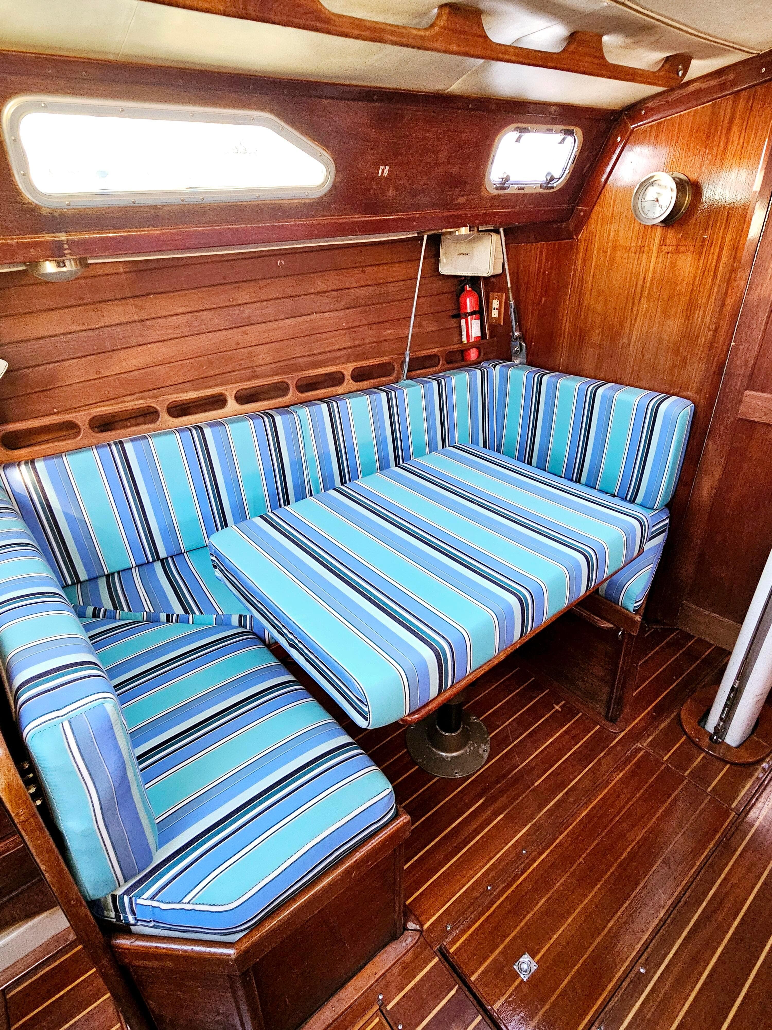 Interior of 1989 Ericson 35 MKIII sailboat with striped blue seating and wooden paneling.