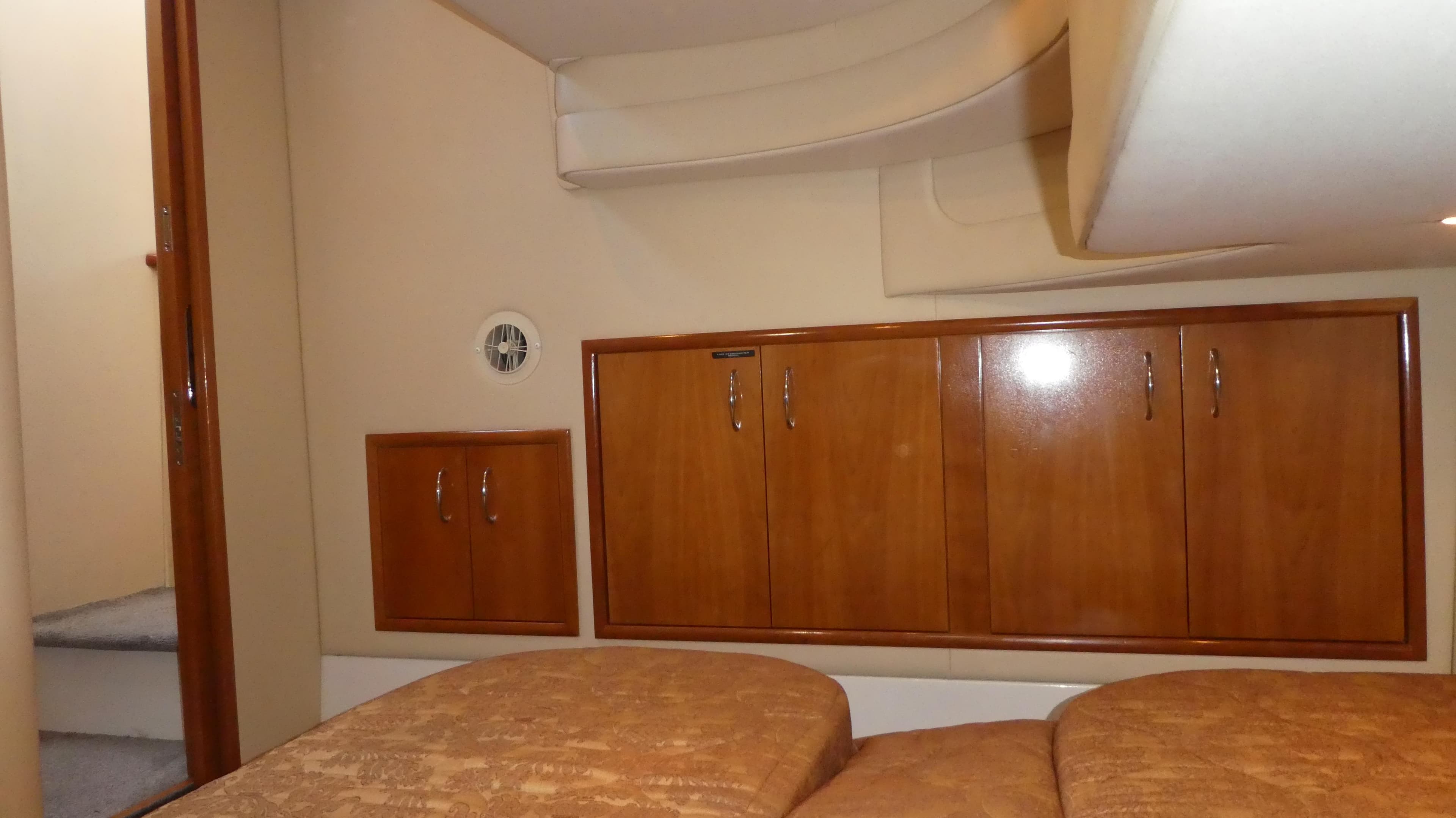 Interior cabin of 2005 Carver 38 Super Sport with wooden cabinets and beige bedding.