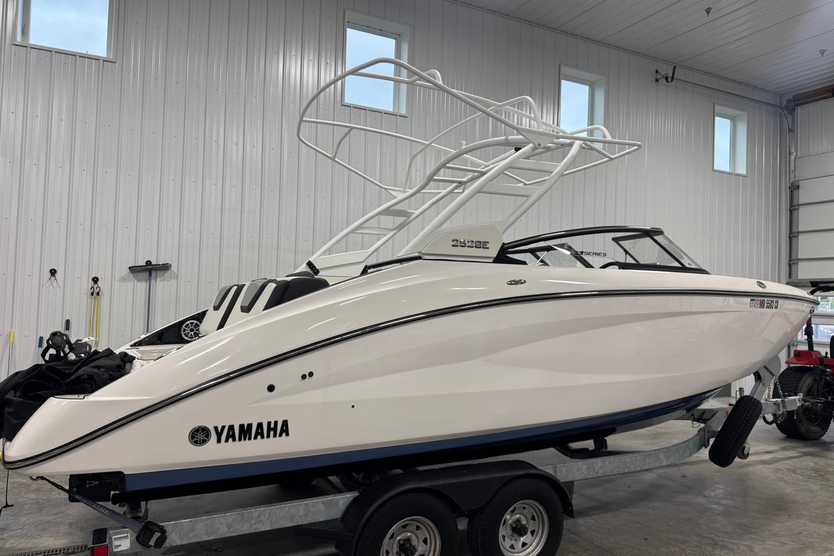 2023 Yamaha Boats 252SE in a garage, showcasing sleek design and modern features.