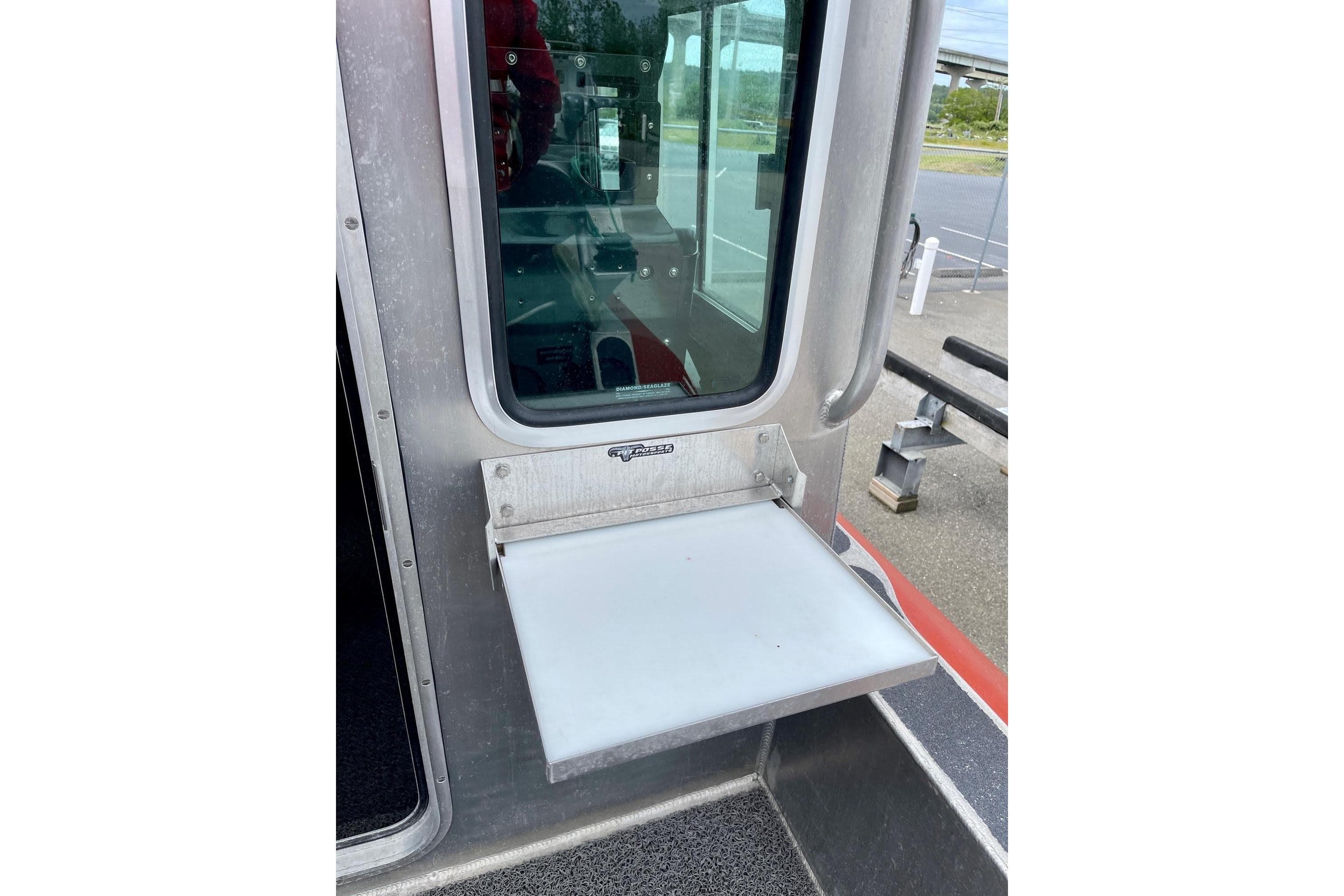 2006 SAFE Boats Defender 25 with foldable side platform near window.