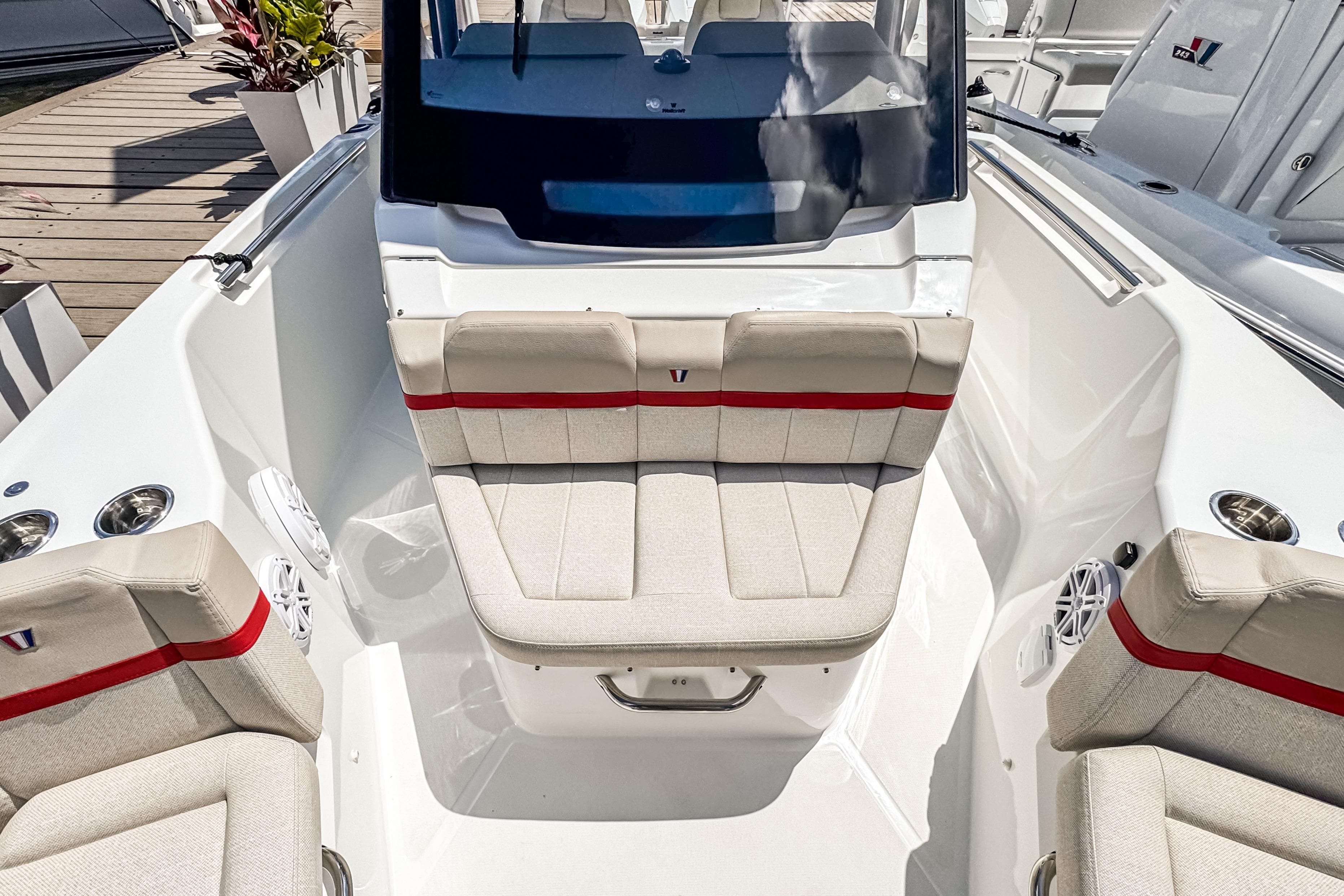 2026 Wellcraft 28 T-Top boat interior with beige seating and red accents.