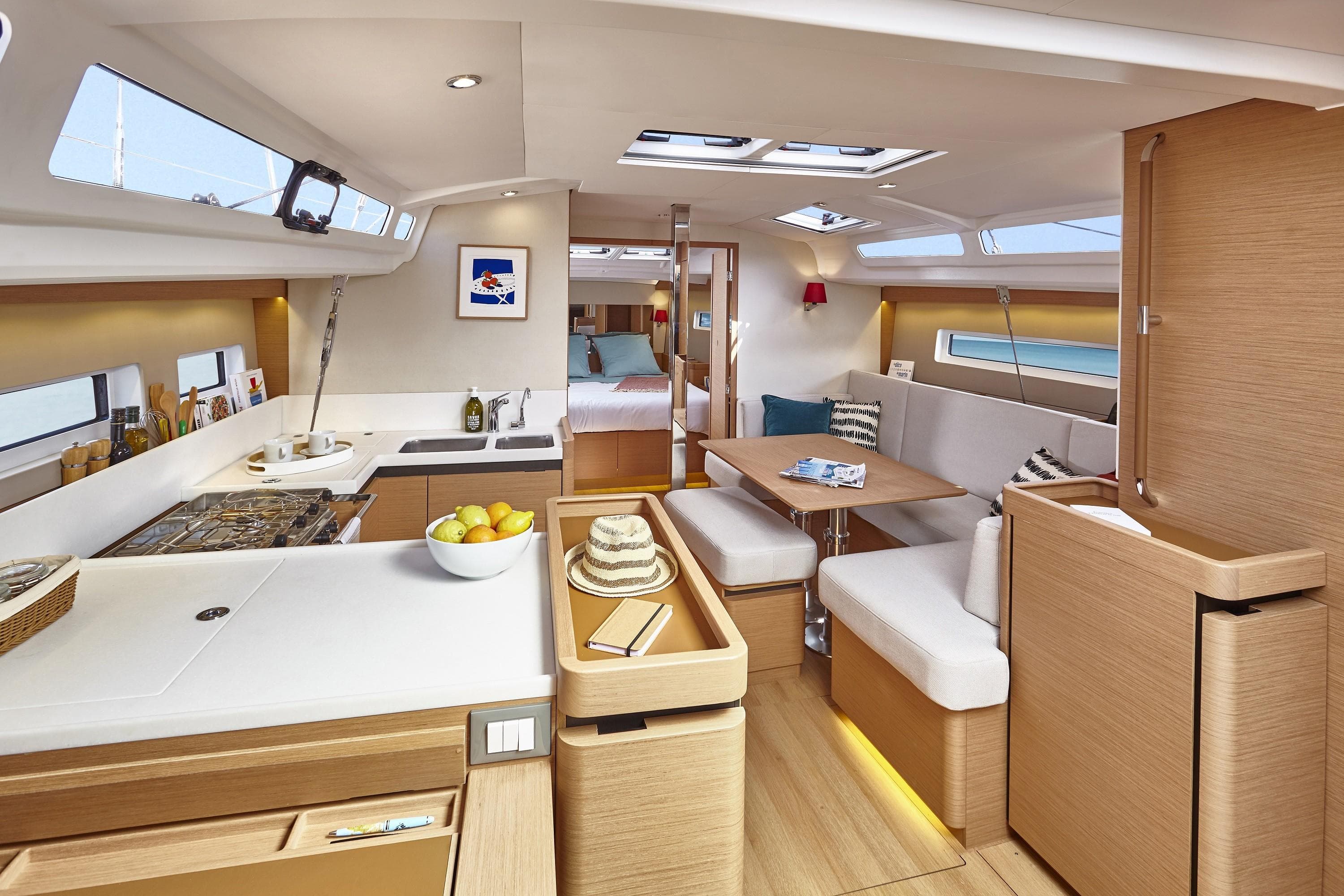Luxurious interior of 2026 Jeanneau 440 yacht with modern kitchen and cozy seating area.