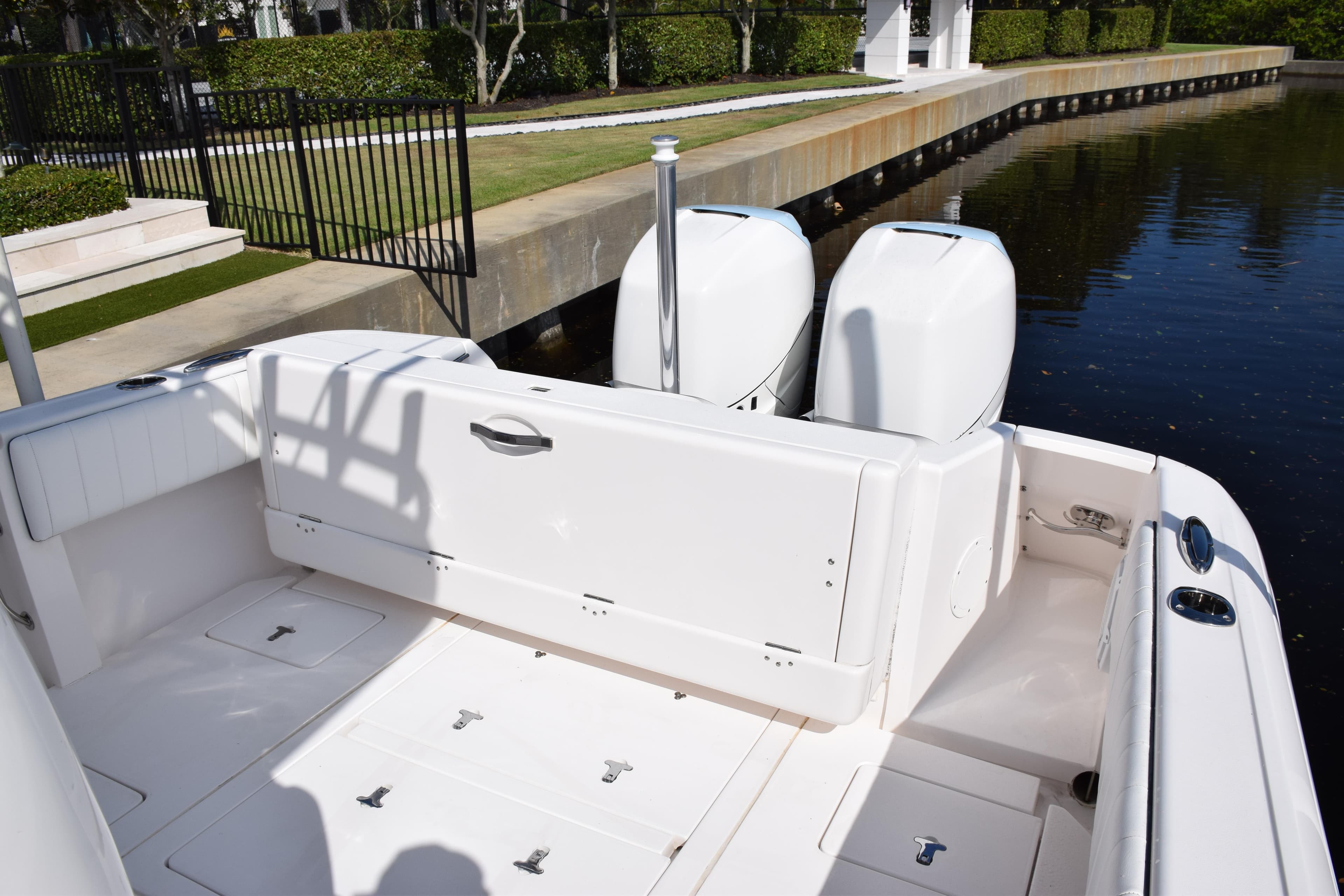 2017 Intrepid 327 boat with dual engines docked by a canal.