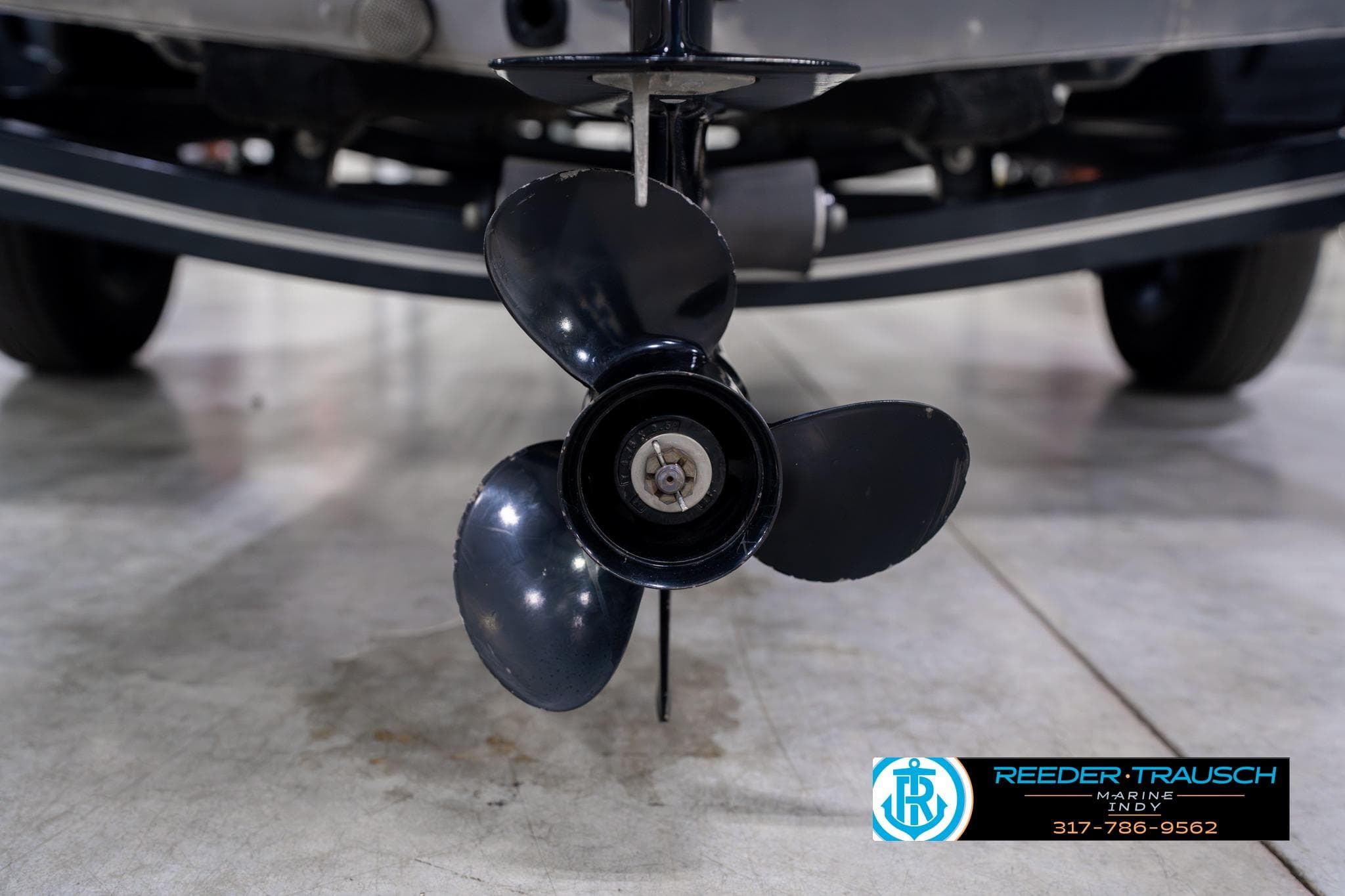 Close-up of a 2023 Lund 1600 Fury Tiller boat propeller in a showroom.