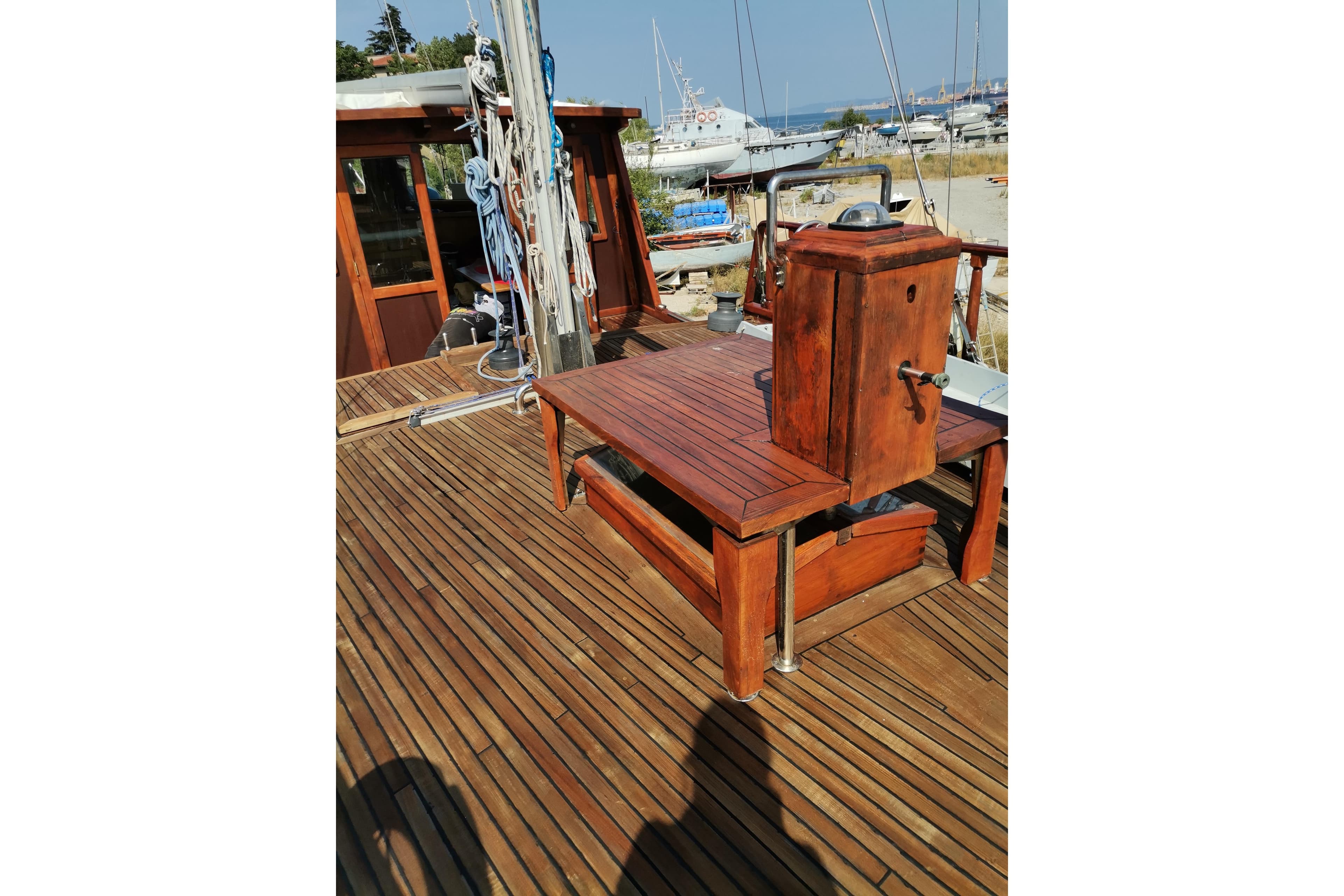 Wooden deck of 1982 Kufra Werft Ketch sailboat, featuring nautical equipment and ropes.