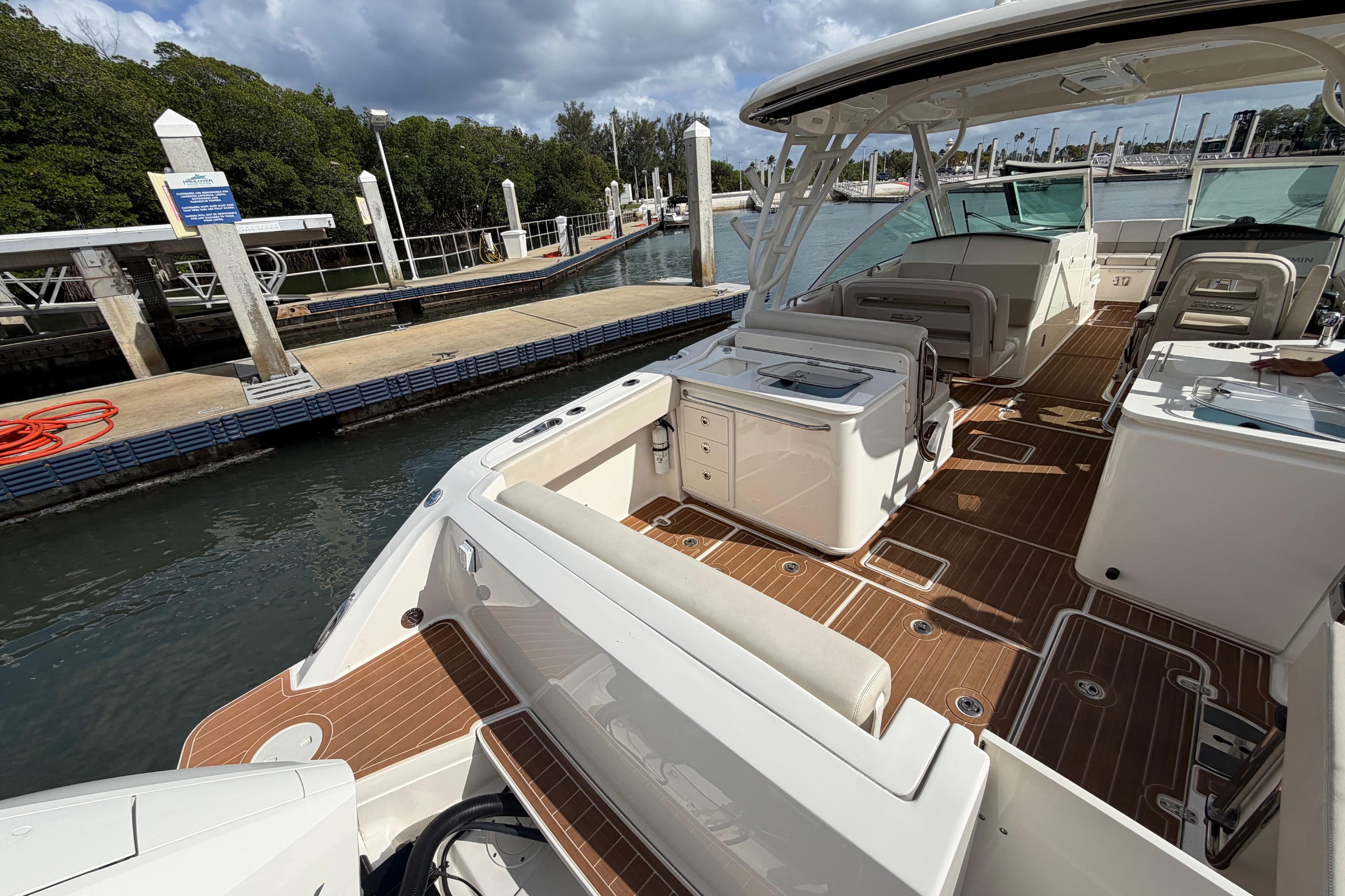 2022 Boston Whaler 320 Vantage docked, showcasing spacious deck and seating area.