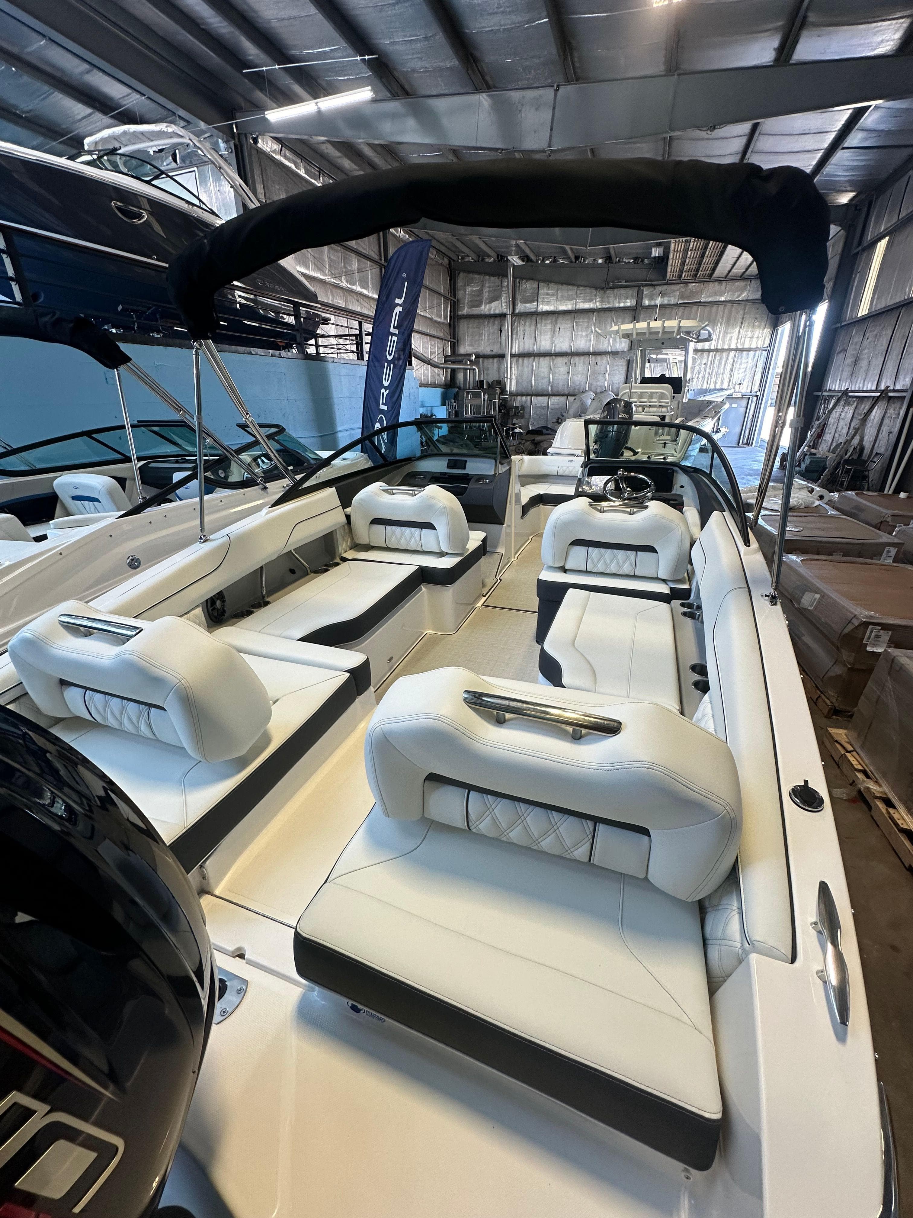 2025 Regal LX2 boat with white seating in a showroom.
