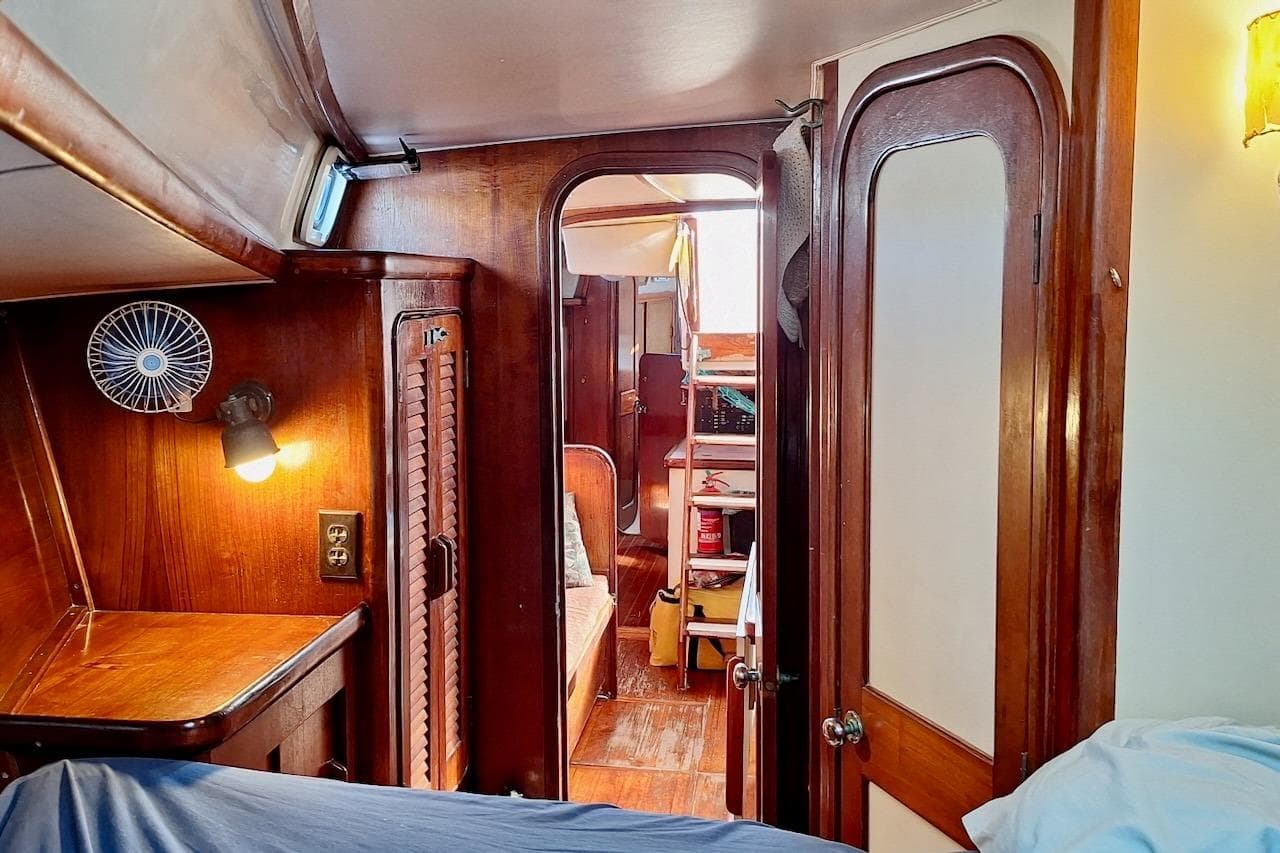 Interior of 1985 Gulfstar Hirsch 45 CC sailboat with wooden cabinetry and cozy lighting.