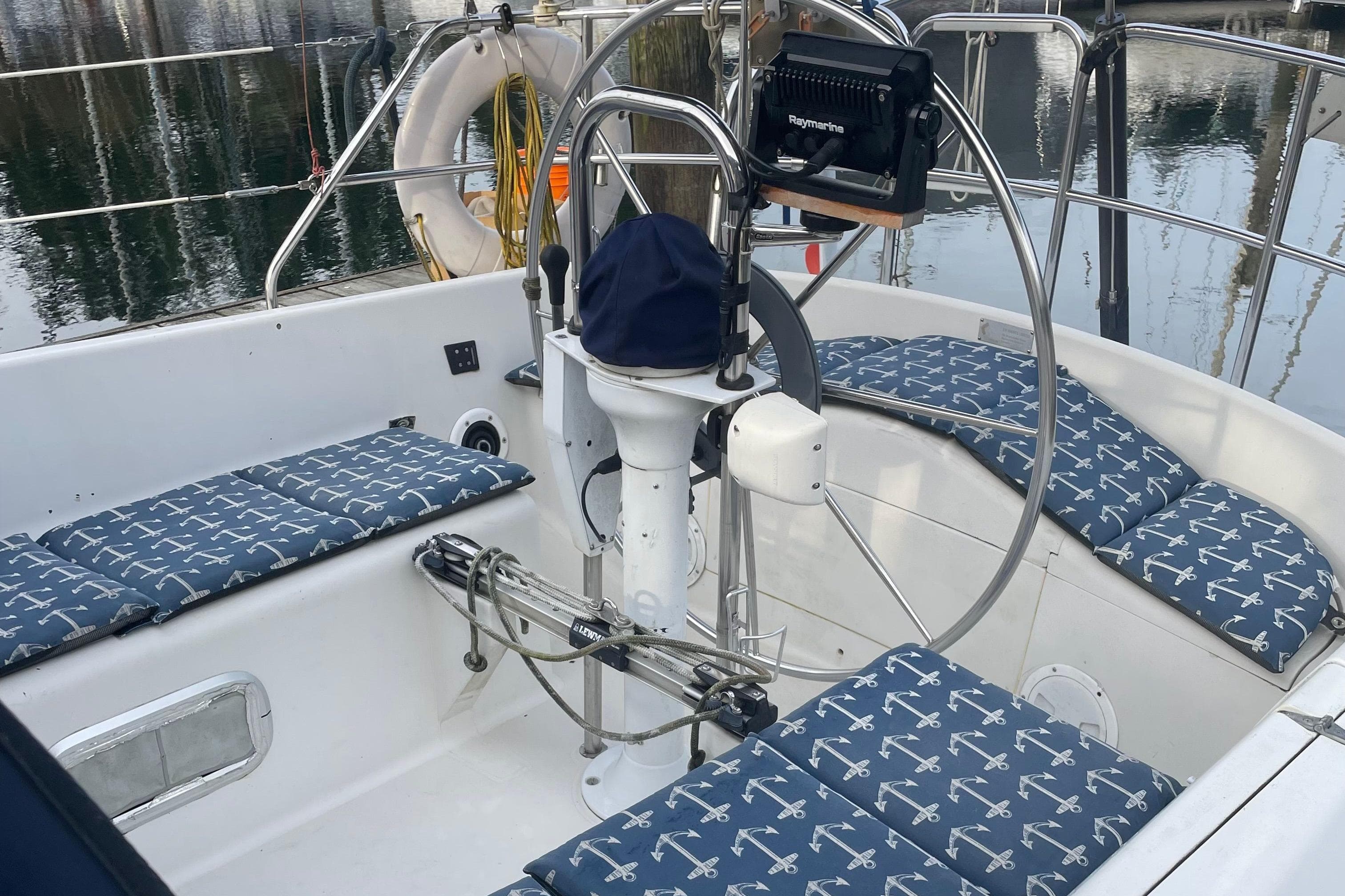 Cockpit of 1988 CS 36 Merlin sailboat with anchor-patterned cushions and steering wheel.