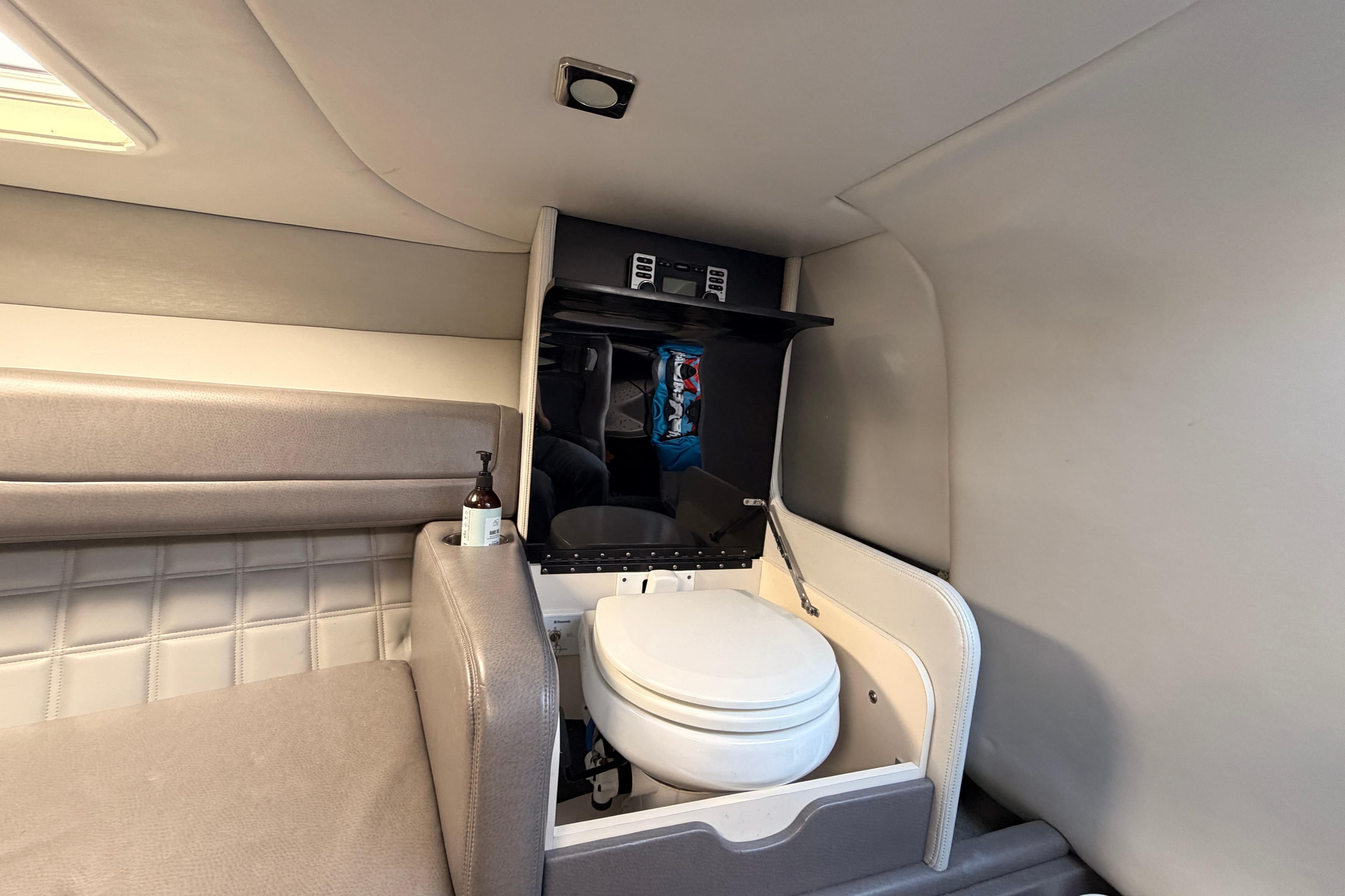 Interior of a 2017 Formula 270 Sun Sport boat featuring a compact marine toilet.