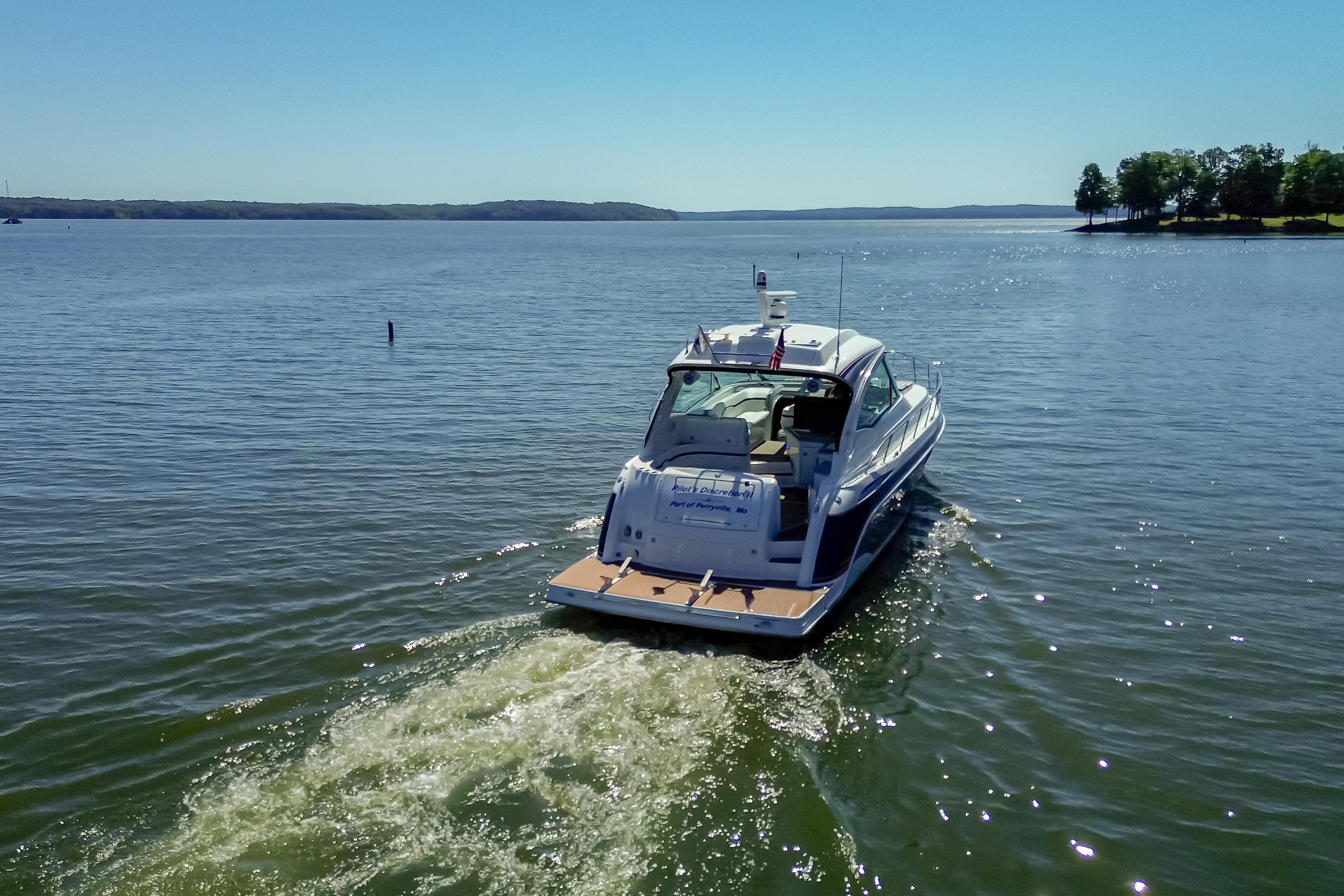 2008 Formula 45 Yacht cruising on a serene lake under clear blue skies.