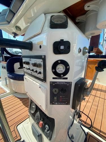 Control panel of a 1989 Irwin 54 yacht with navigation instruments and teak flooring.