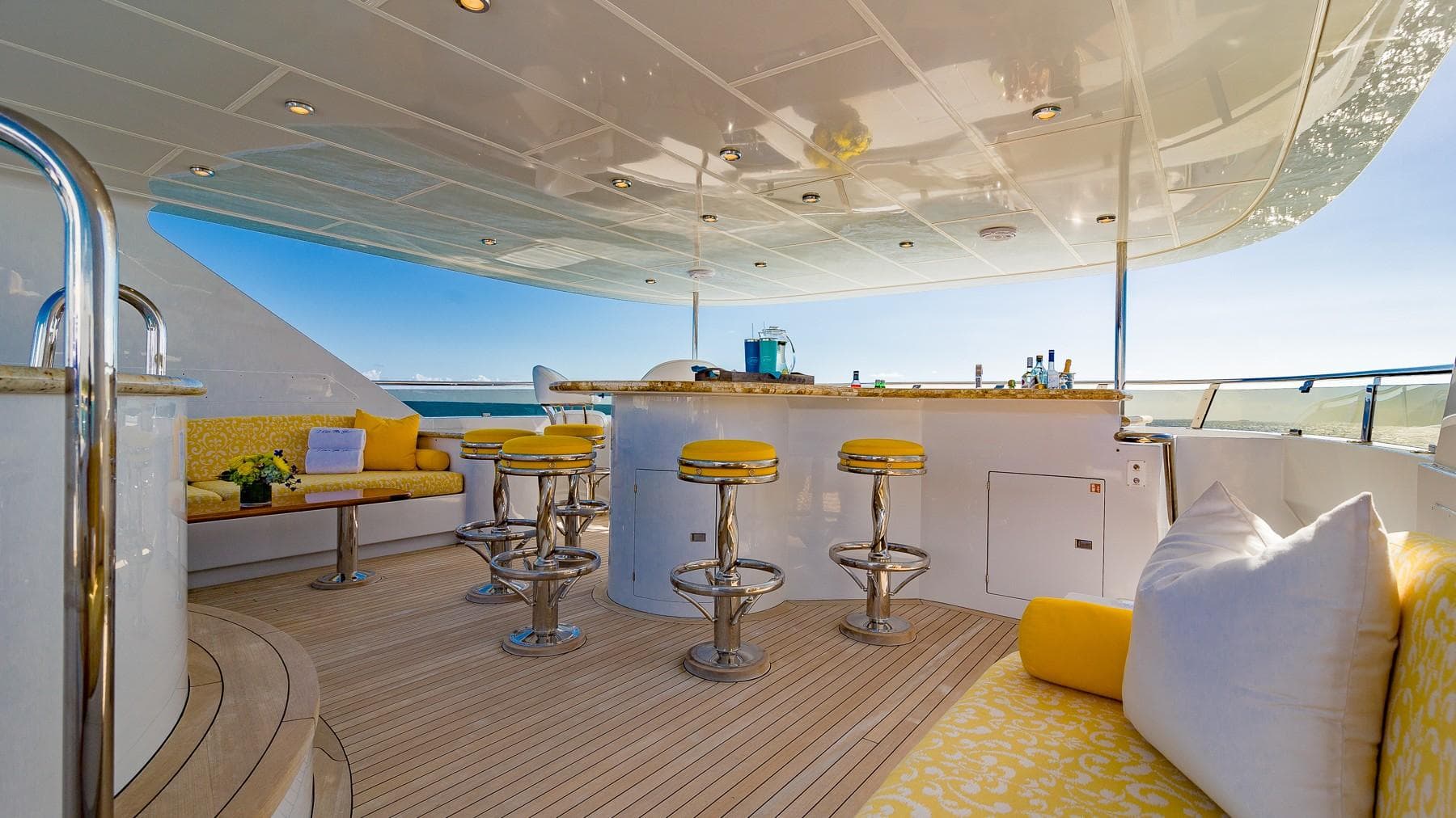 Luxurious 2002 Christensen Tri Deck yacht with elegant outdoor bar and seating area.