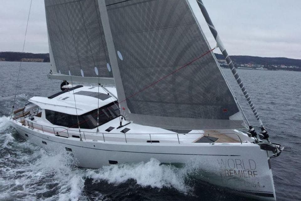 2025 Moody 54 DS sailing yacht navigating through waves on open water.