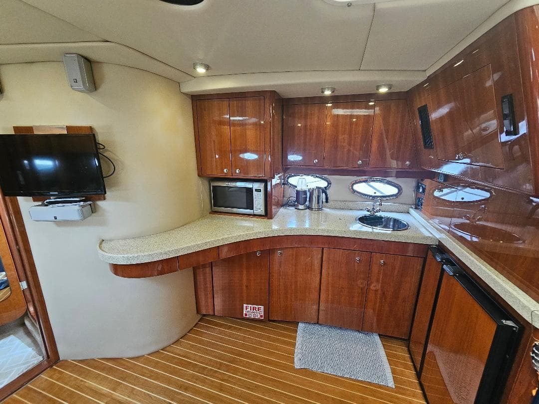 2007 Regal Commodore 4460 yacht kitchen with wooden cabinets and modern appliances.