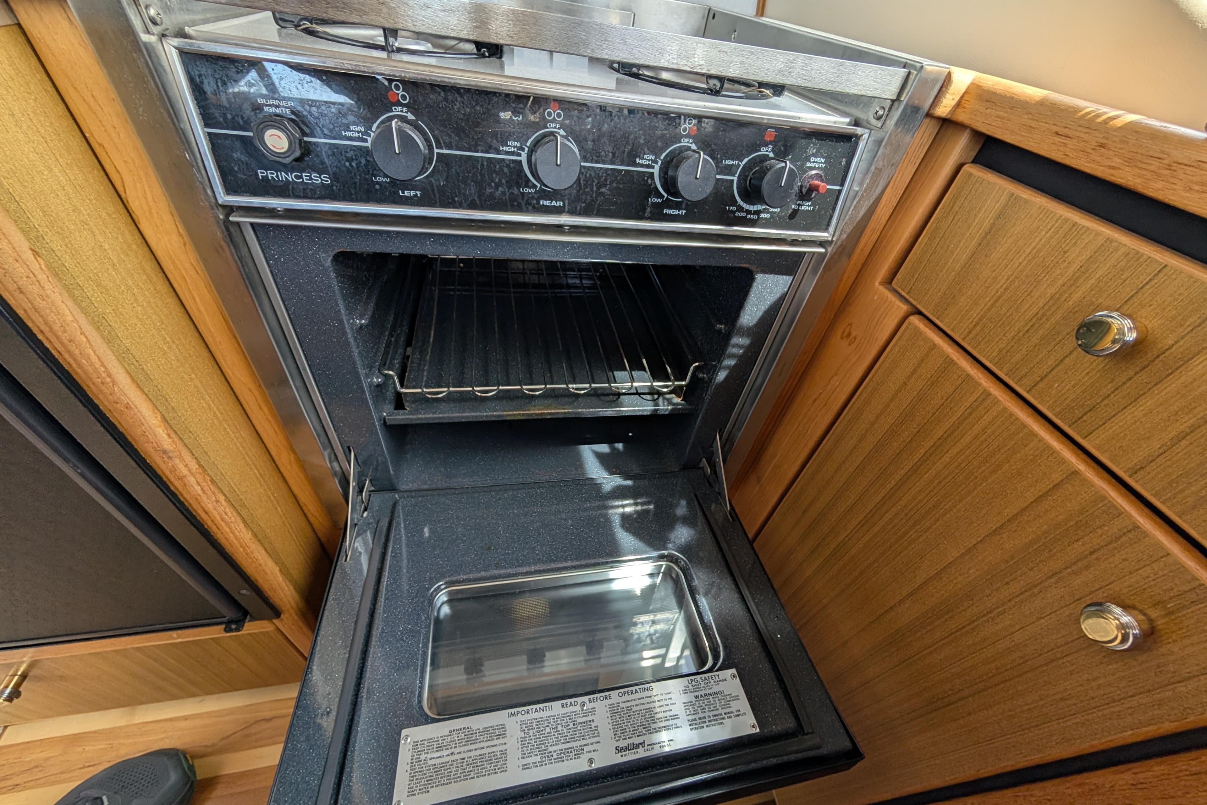 Open oven in 2000 Bayliner 4088 yacht kitchen, featuring wooden cabinetry and modern controls.