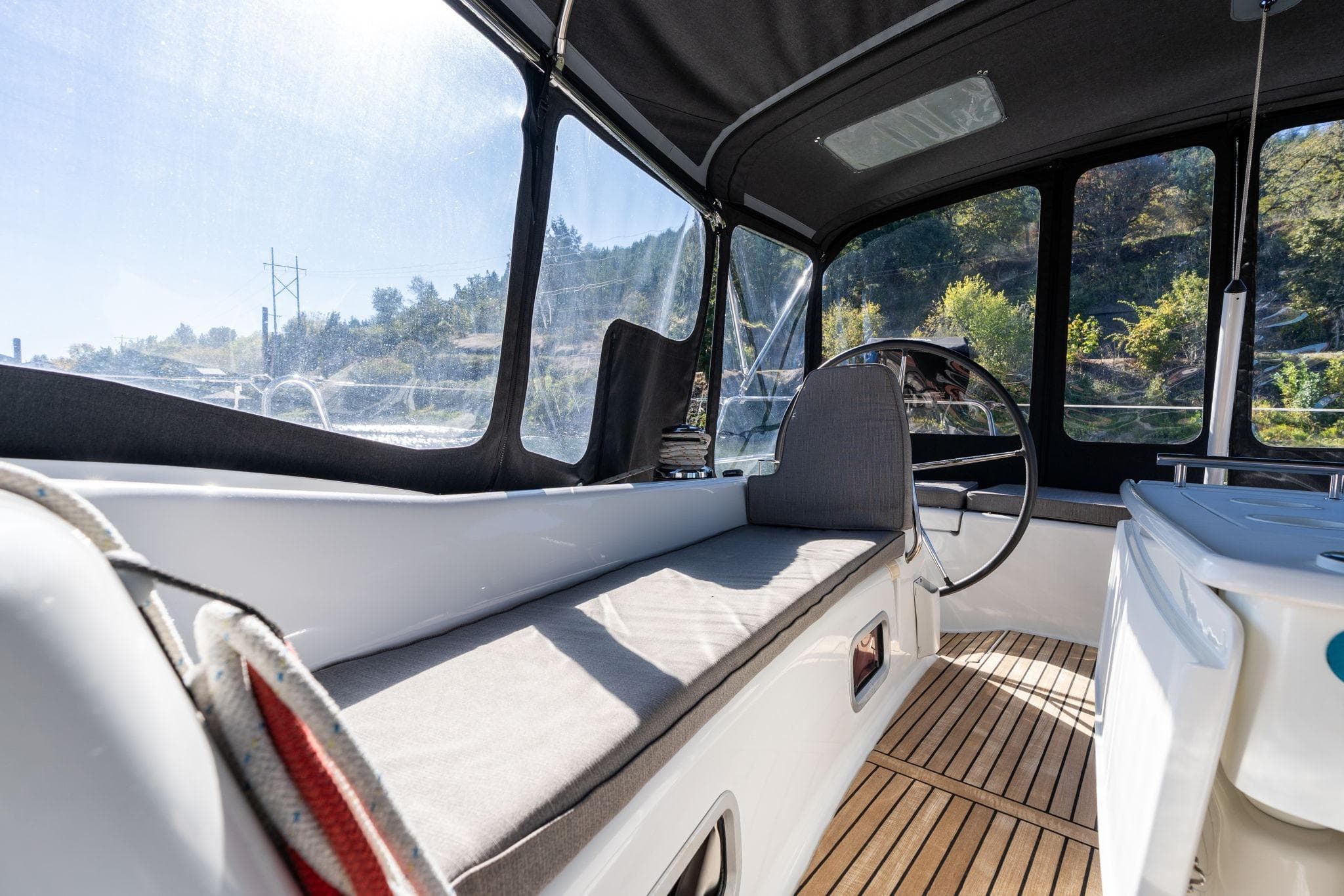 Interior view of 2013 Beneteau Oceanis 50 sailboat cockpit with seating and steering wheel.