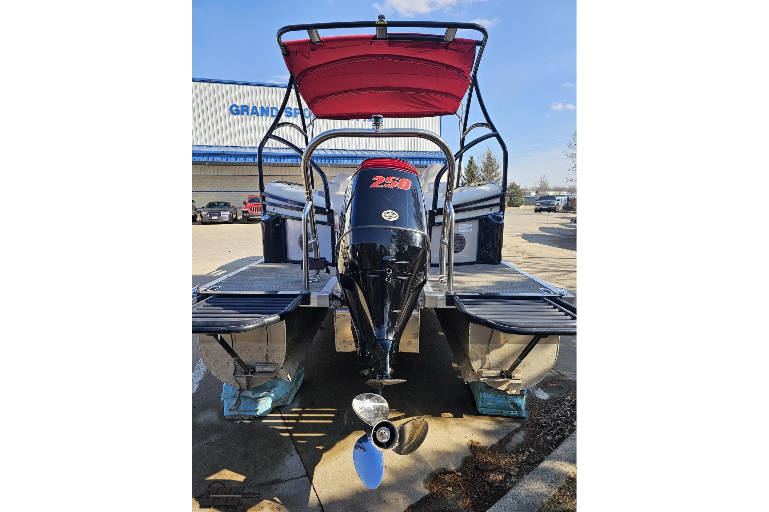 2019 JC Tritoon Neptoon 25 Sport SL with powerful outboard motor, parked outdoors.