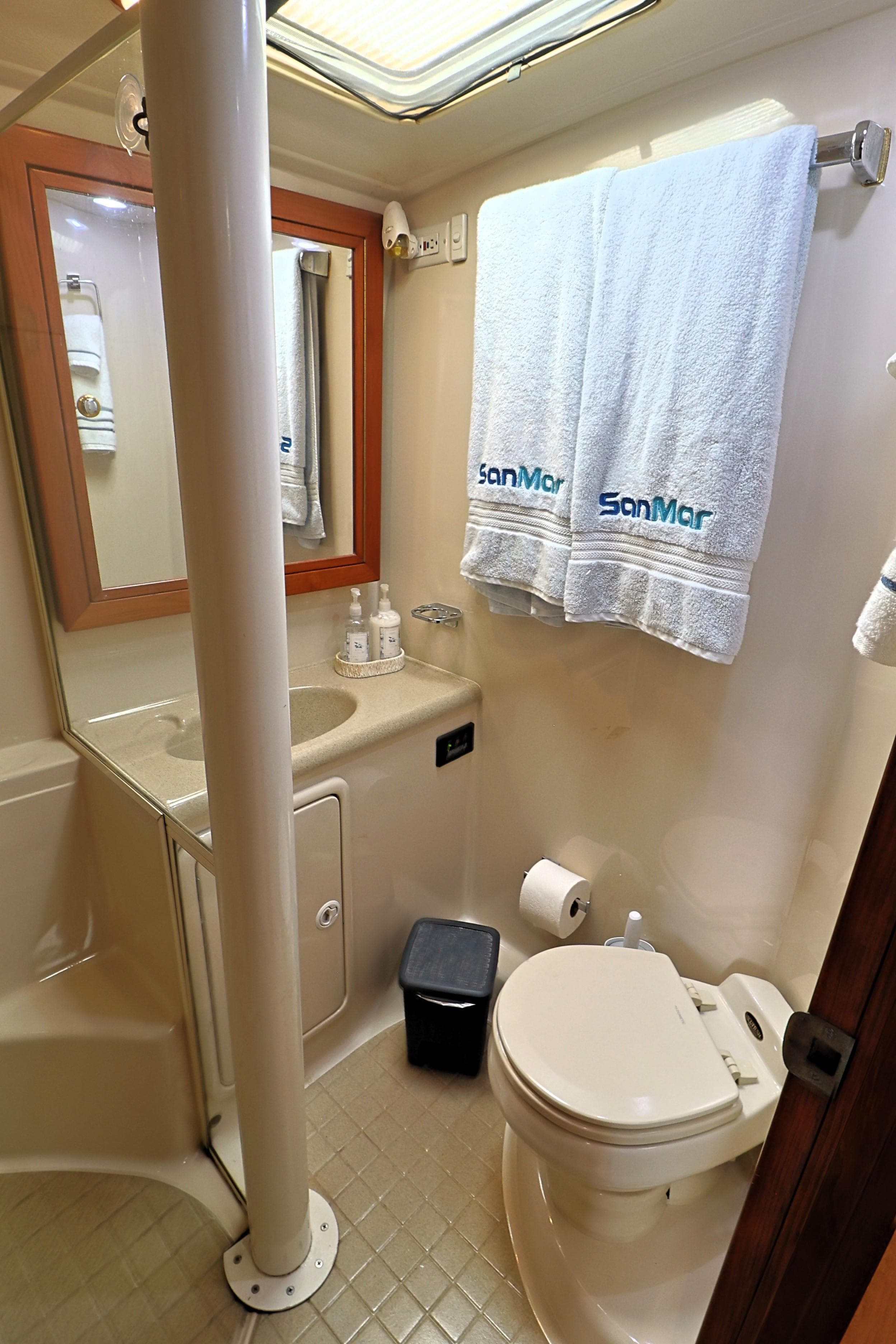 Bathroom interior of 2000 Riviera Flybridge Convertible yacht, featuring toilet, sink, and towels.
