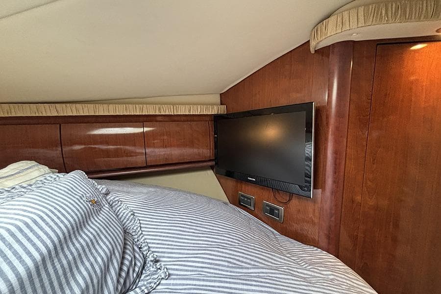 Interior cabin of 2006 Sea Ray 44 Sundancer with TV and striped bedding.