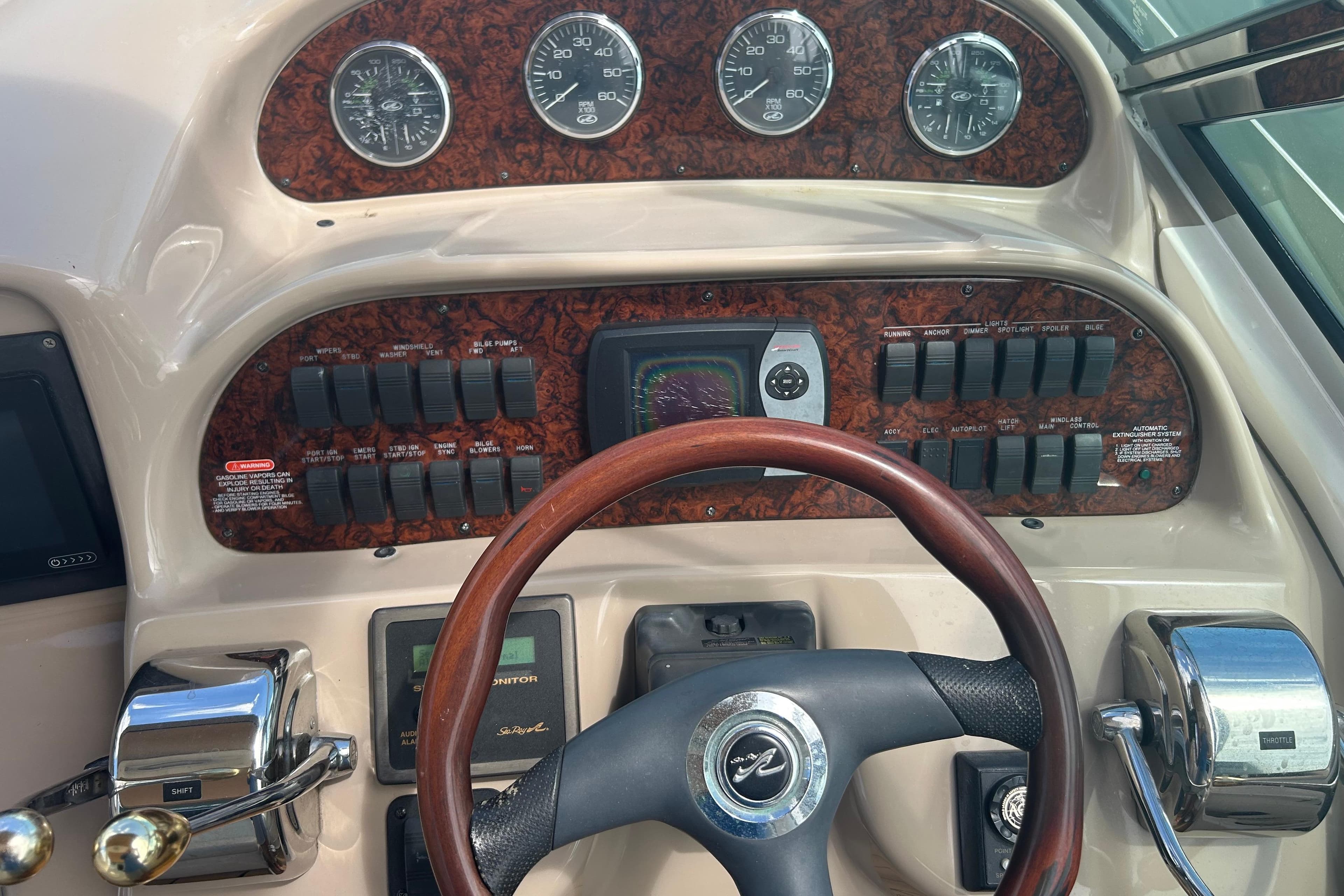 Control panel of a 2005 Sea Ray 360 Sundancer boat with gauges and switches.