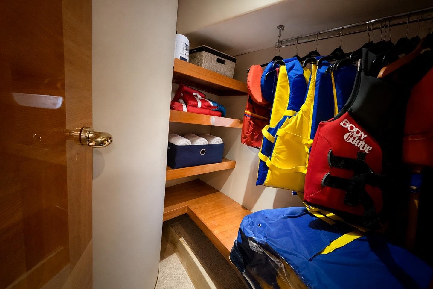 Storage area on 2005 Azimut Fly 62 yacht with life jackets and shelves.
