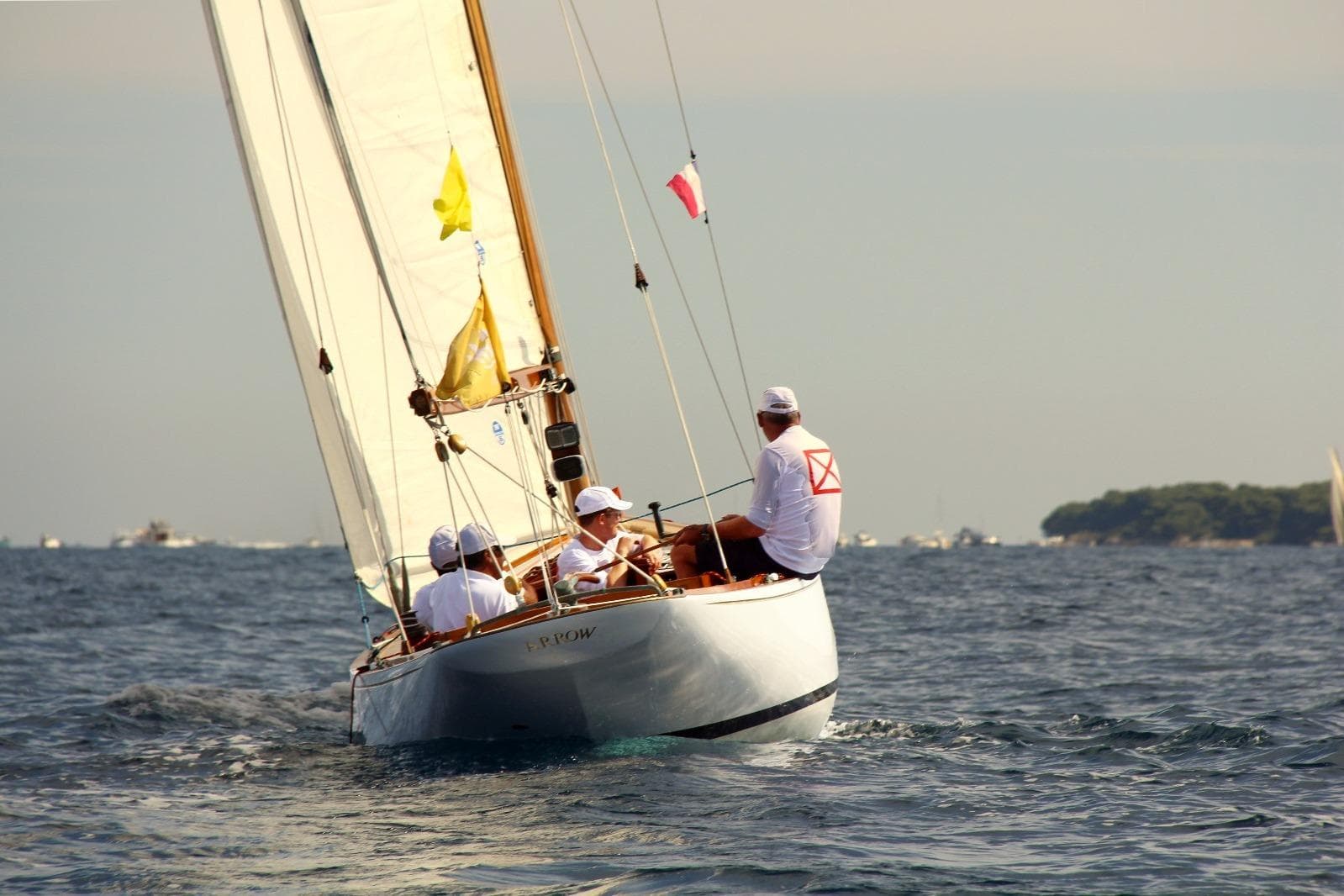 Classic 1924 West Solent One Design sailboat "ARROW" sailing with crew on open water.