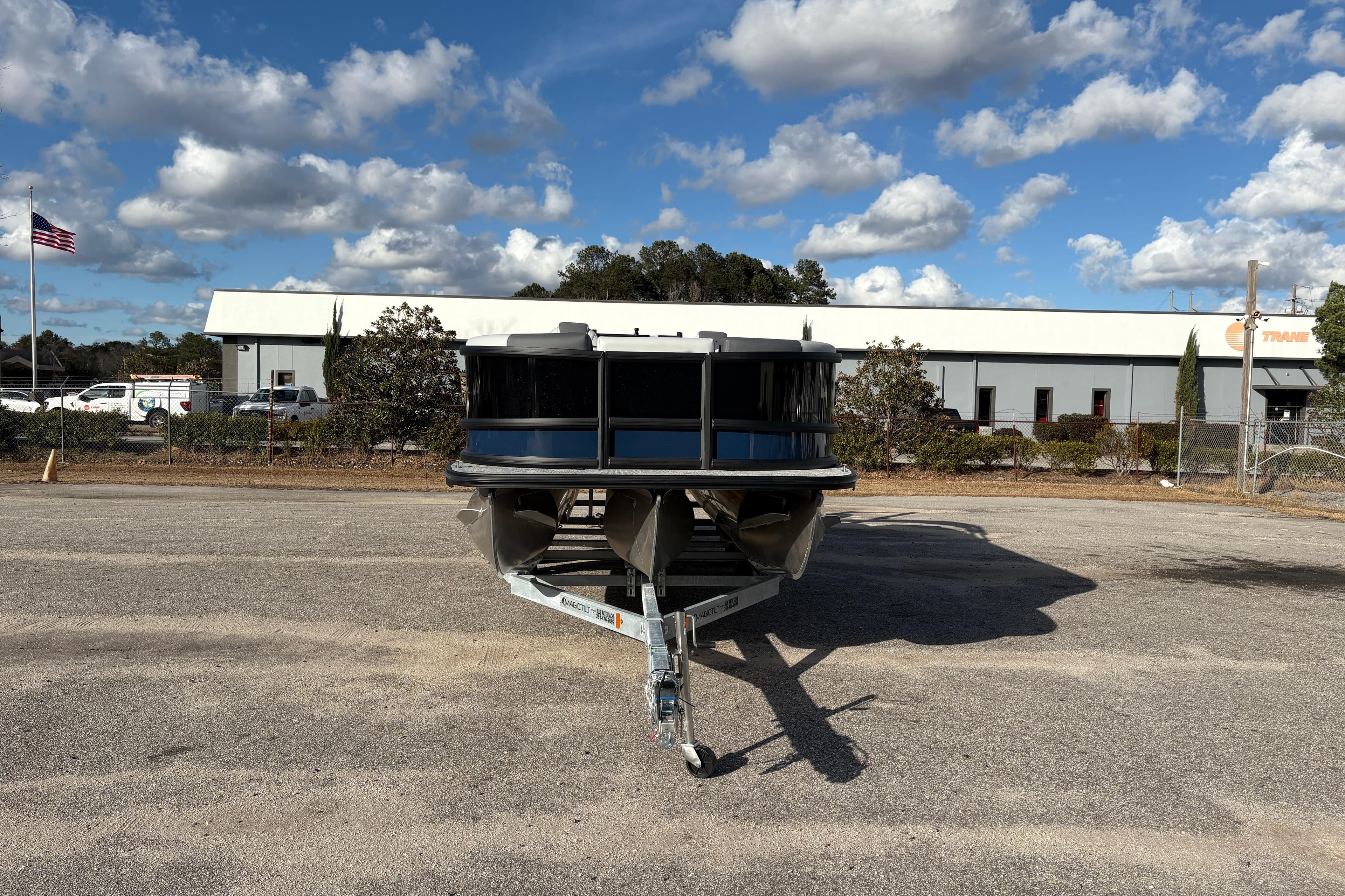 2026 Alera M 23Q boat on trailer in industrial parking lot under blue sky.