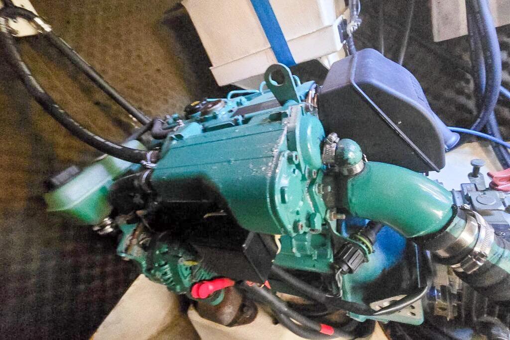 Engine of a 2006 Dolphin 460, featuring green components and black hoses.