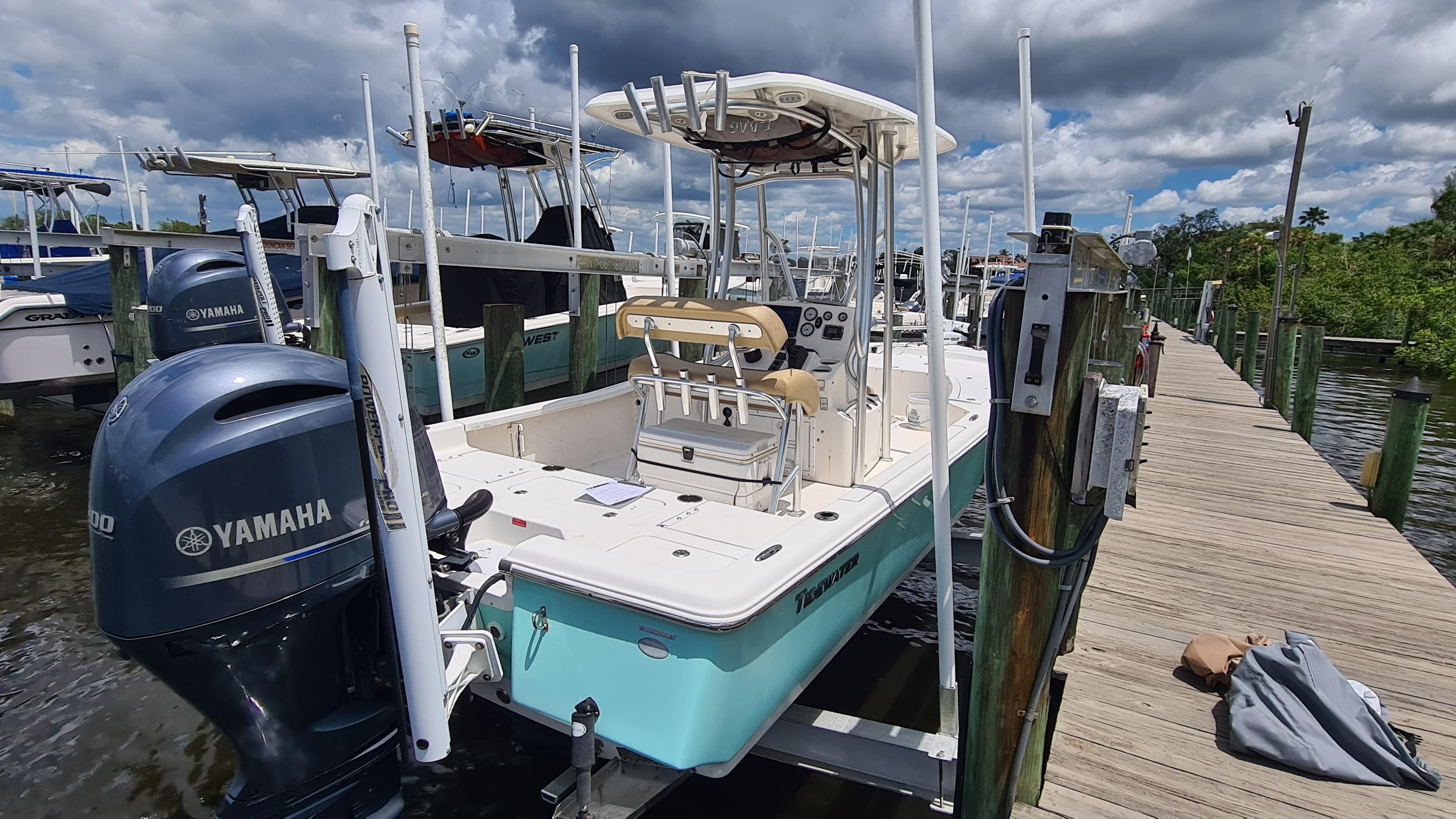 2016 Tidewater 2200 Carolina Bay boat docked with Yamaha engine, under cloudy sky.