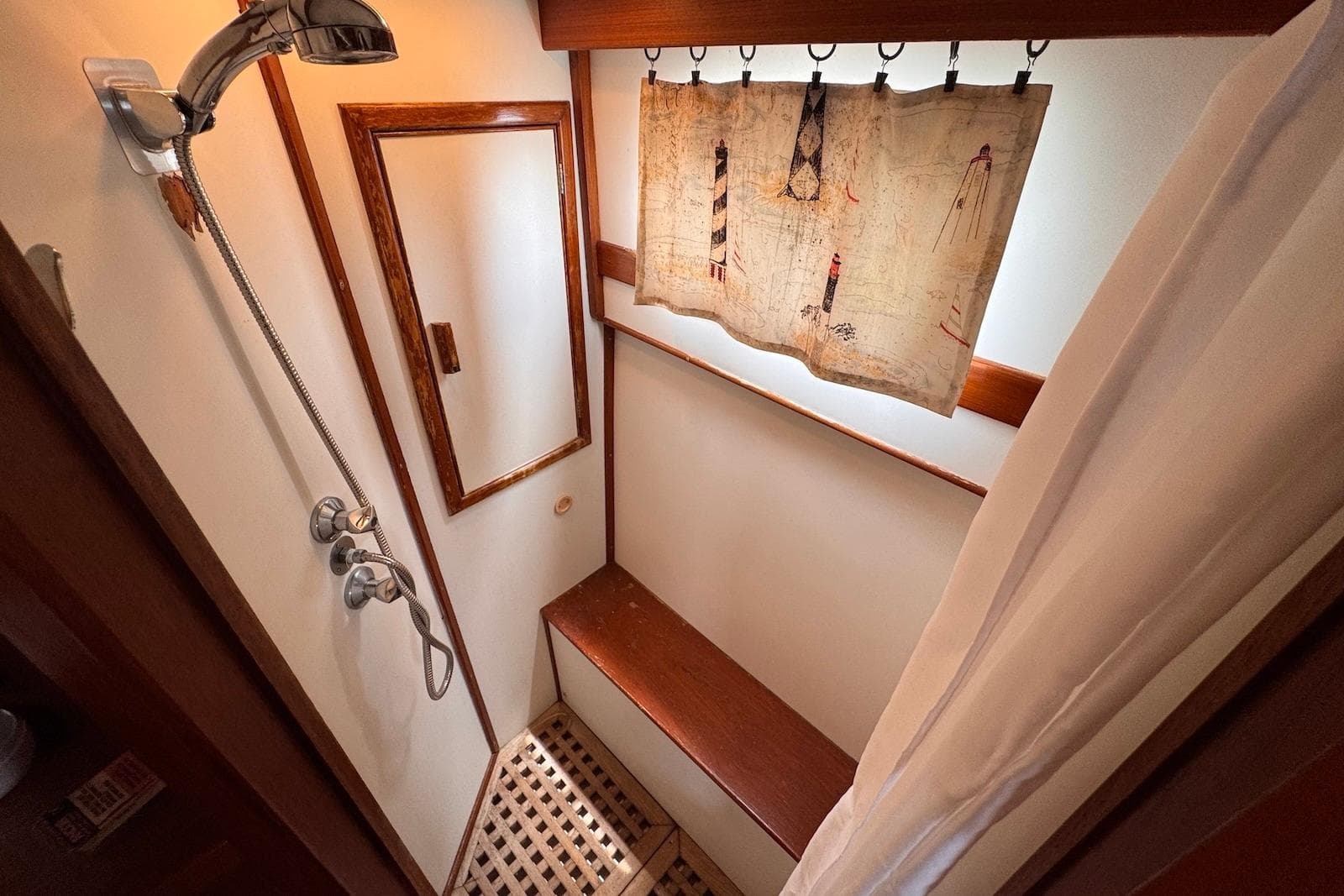 Shower area in 1989 Grand Banks 42 Motoryacht with wooden accents and nautical curtain.