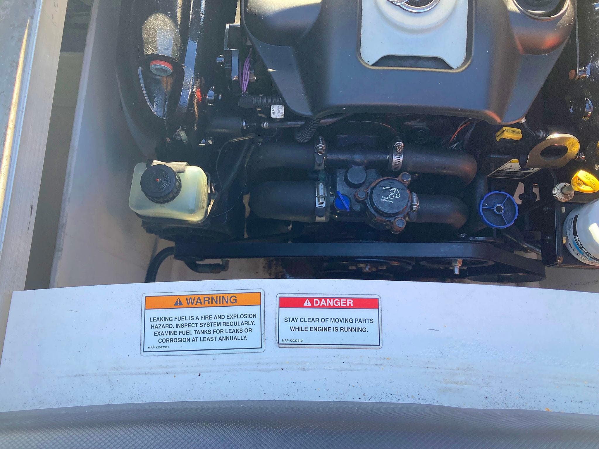 Engine compartment of a 2012 Sea Ray 190 Sport with warning labels visible.