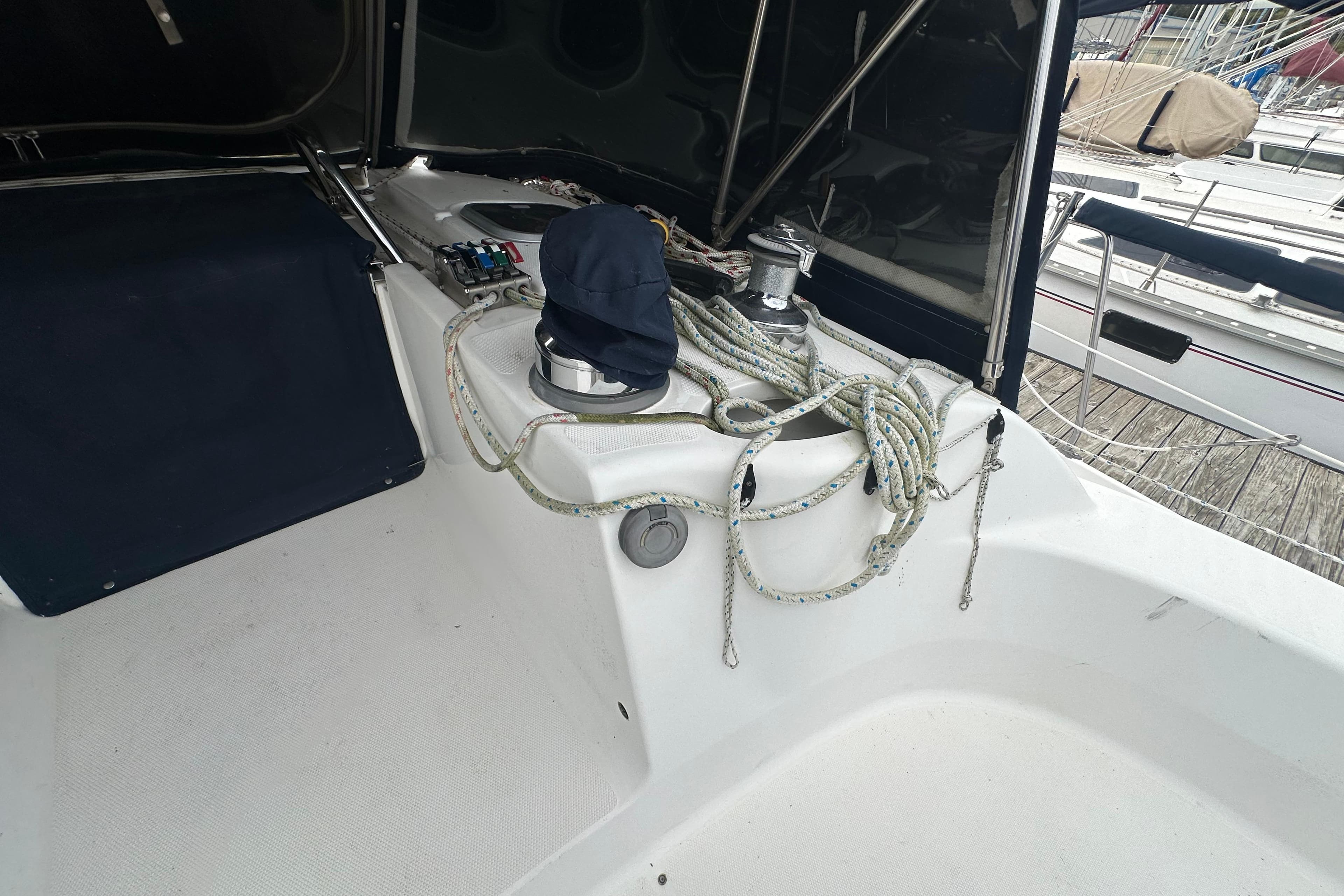 Cockpit of 1997 Hunter 376 sailboat with ropes and winch, docked at marina.