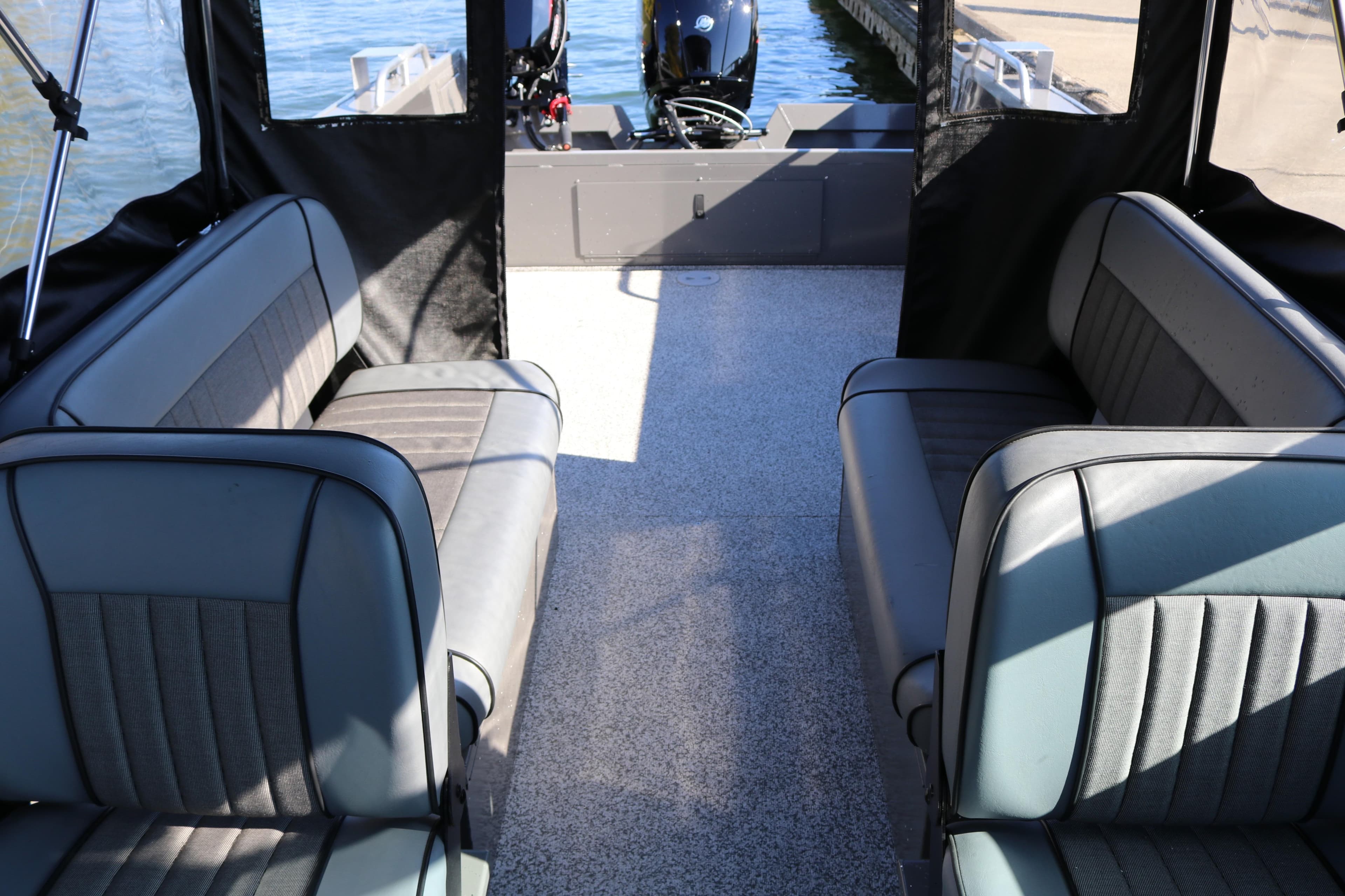 2026 Alumaweld Stryker 220 boat interior with cushioned seating and outboard motor.