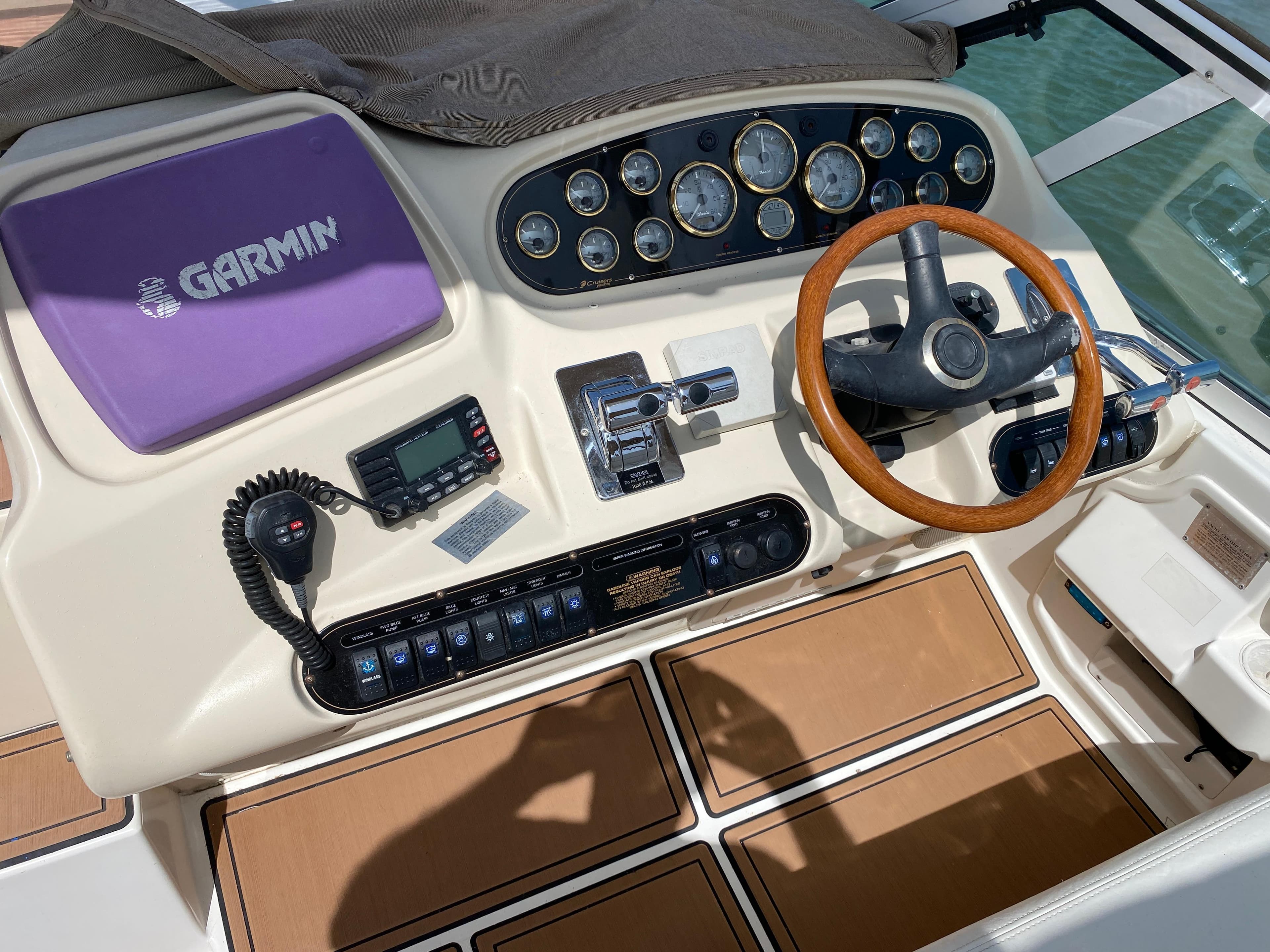 Cruisers 3672 2000 boat dashboard with Garmin navigation and wooden steering wheel.