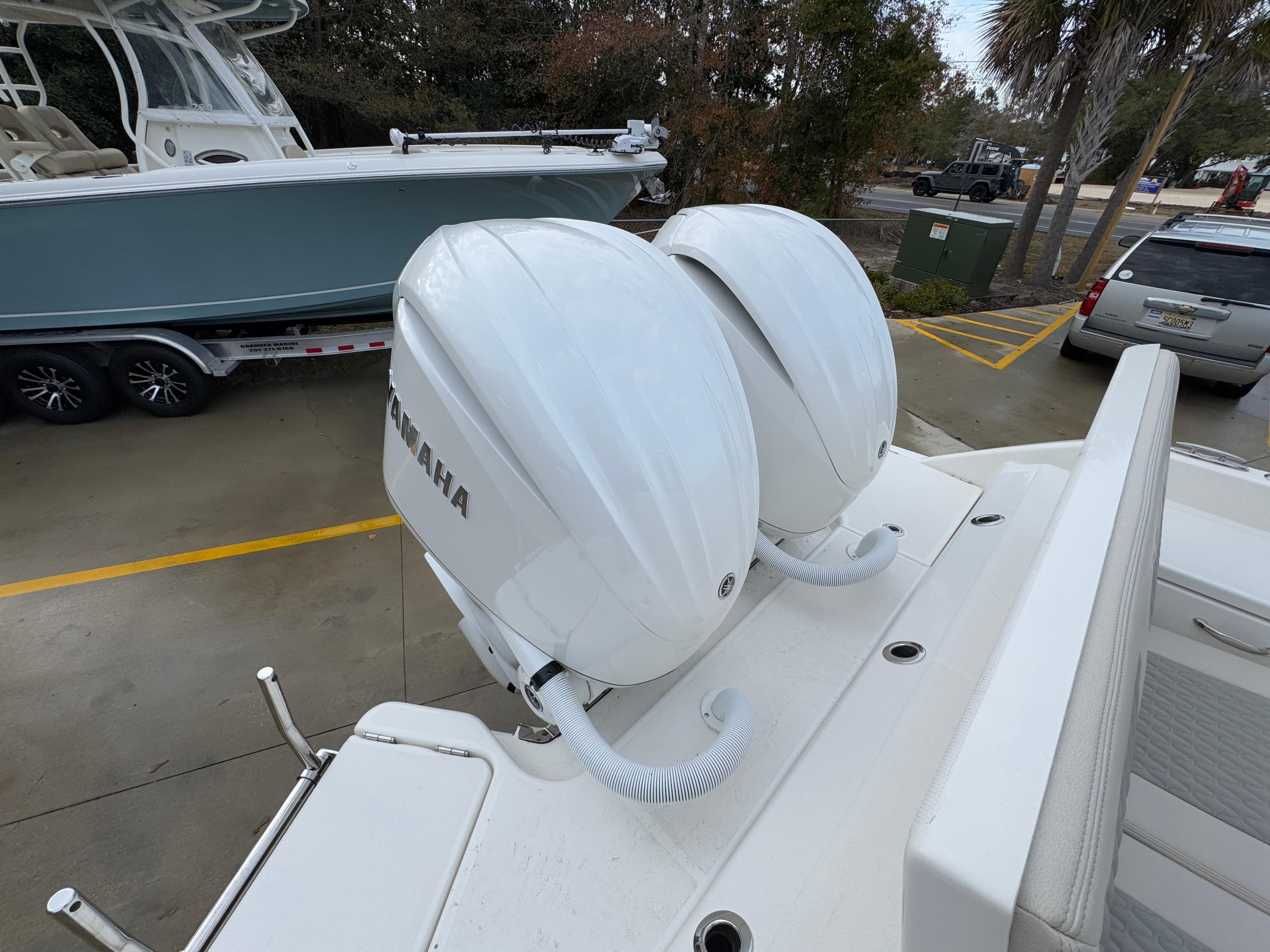 Twin Yamaha outboard engines on a 2025 Solace 28 HCS boat, parked outdoors.